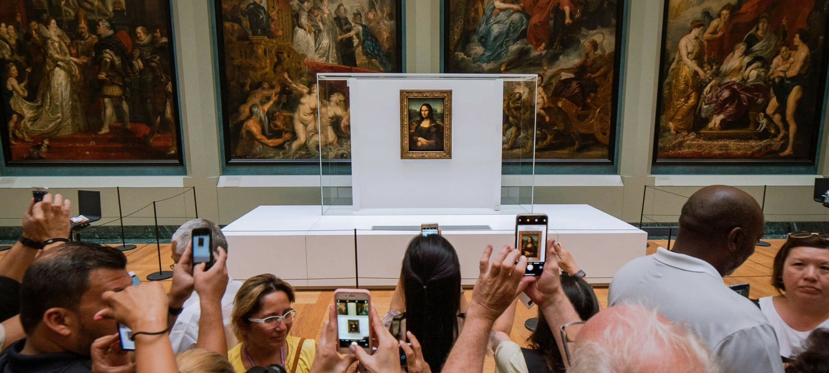 Mona Lisa painting displayed in front of crowd taking pictures