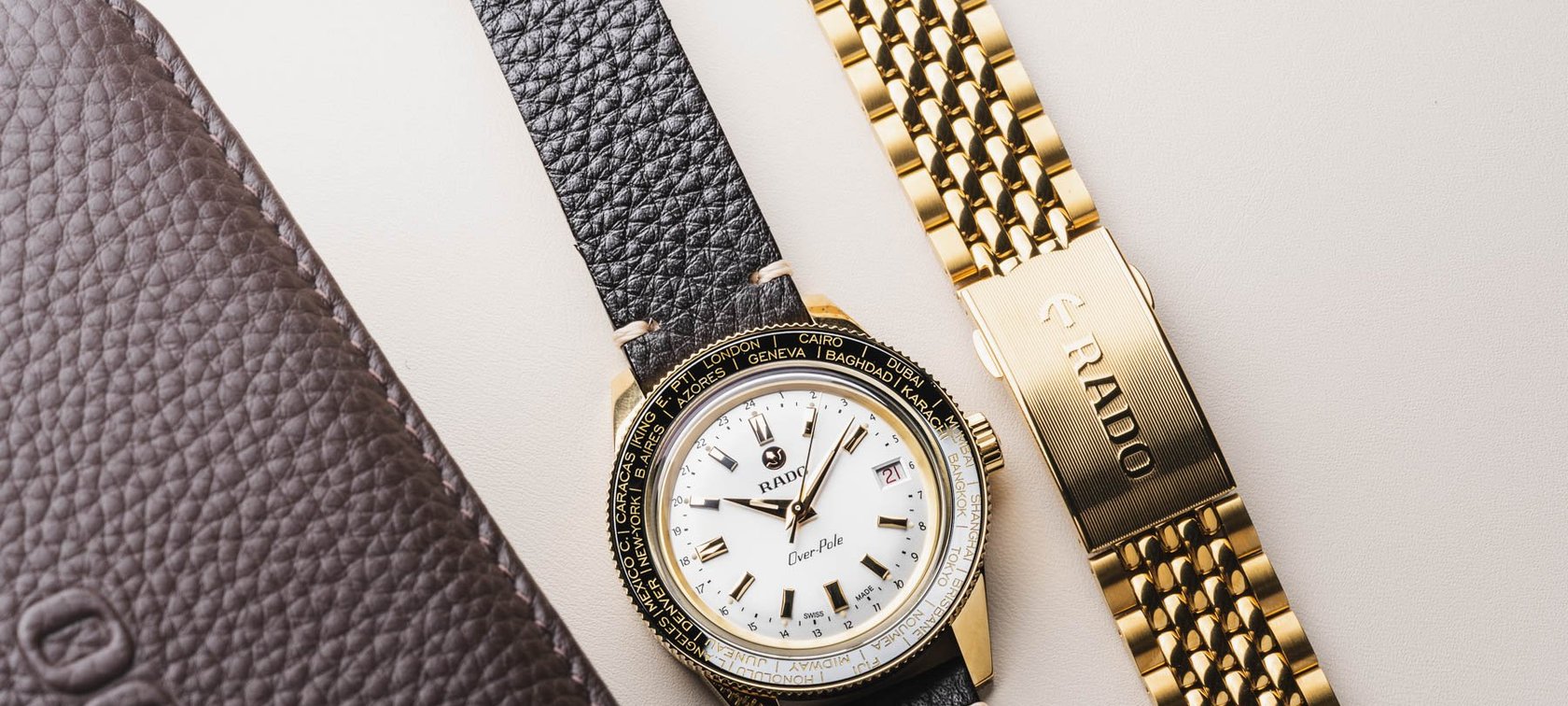 Rado Captain Cook Over-Pole in gold PVD between bracelet and leather pouch