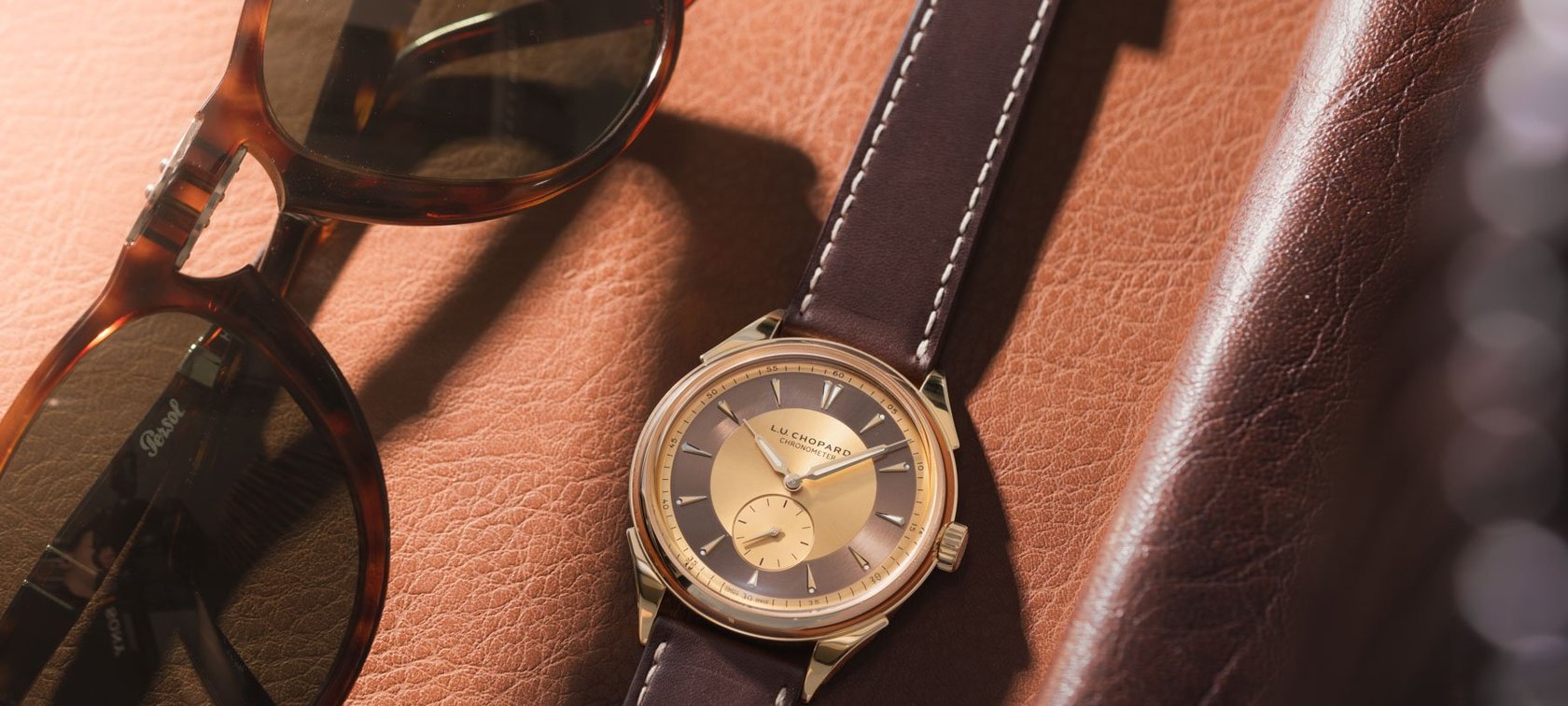 Chopard L.U.C Qualité Fleurier 20th Anniversary Edition flat-lay with sunglasses and phone case