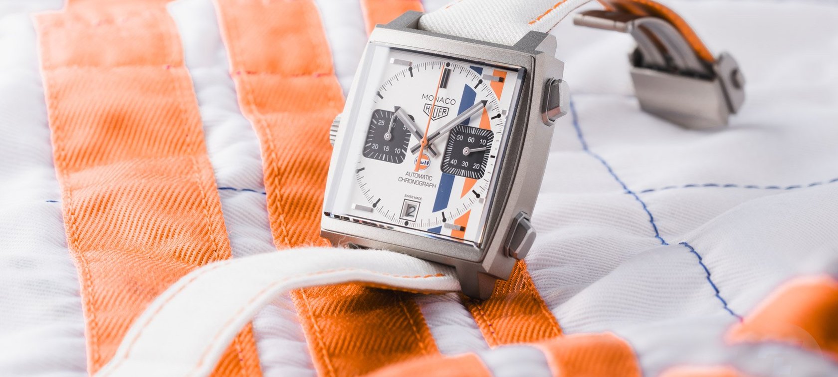 TAG Heuer Monaco Chronograph × Gulf propped up on top of racing suit
