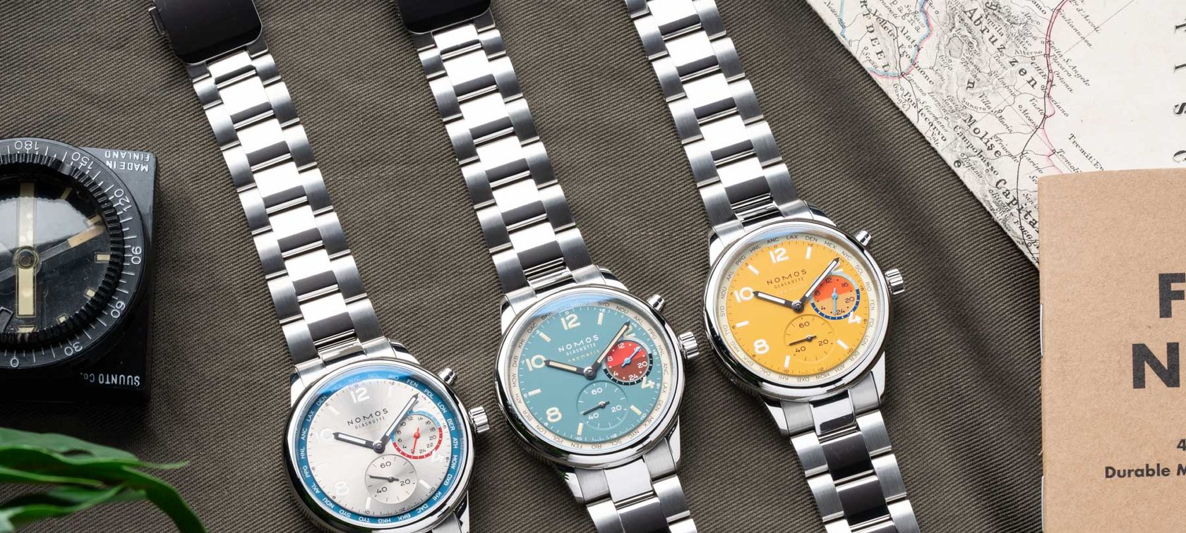 flat-lay of three Nomos Club Sport Neomatik Worldtimer models