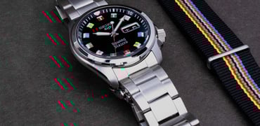 Seiko 5 Sports × Rowing Blazers SRPJ63 flat next to NATO strap