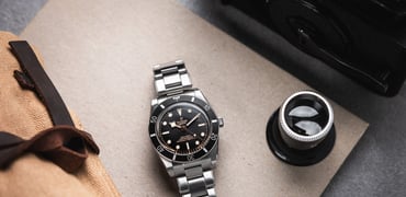 Tudor Black Bay 54 flat-lay with loupe and canvas pouch
