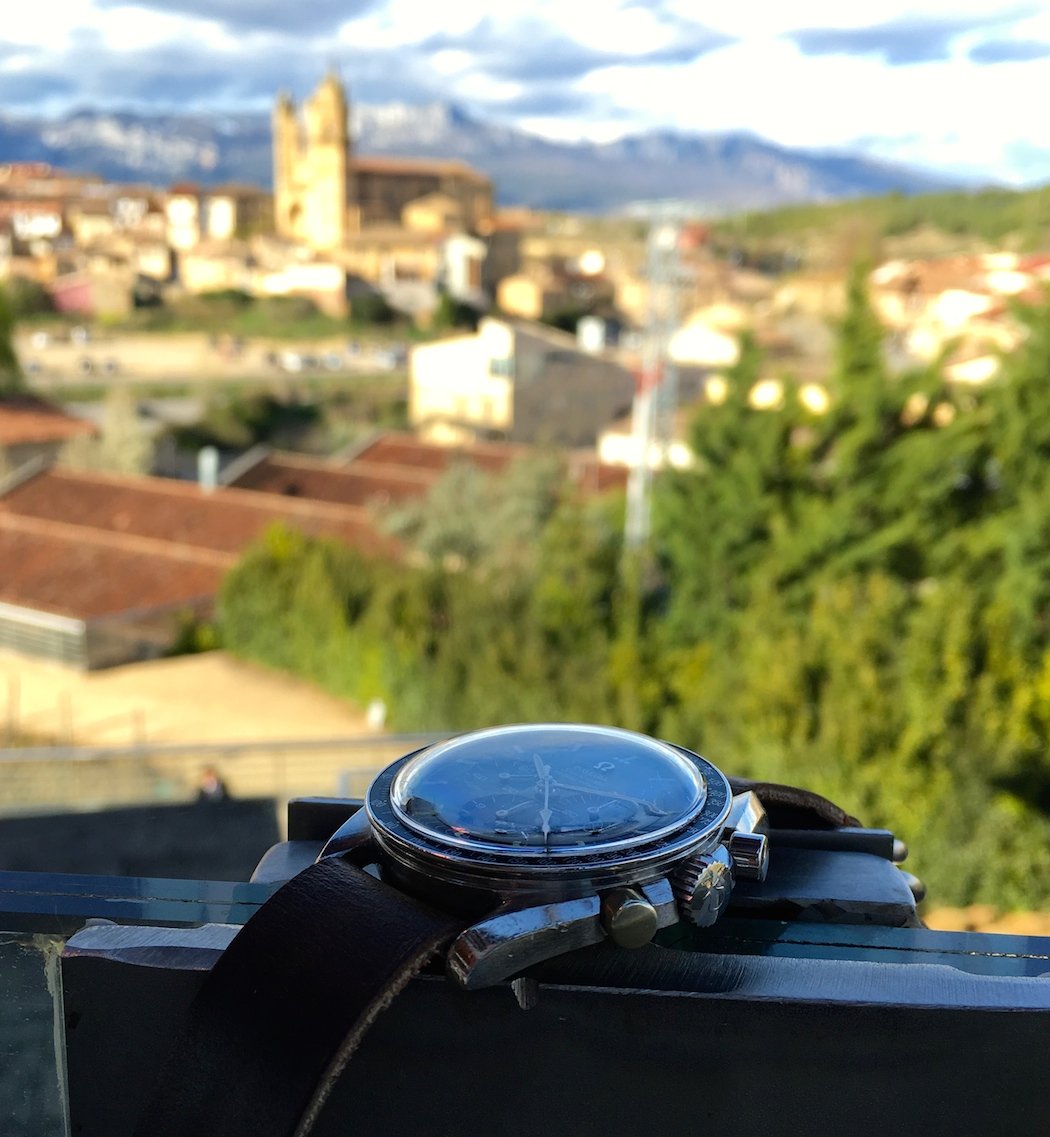 The Omega Speedmaster 145.012 against a backdrop of the town of Elciego