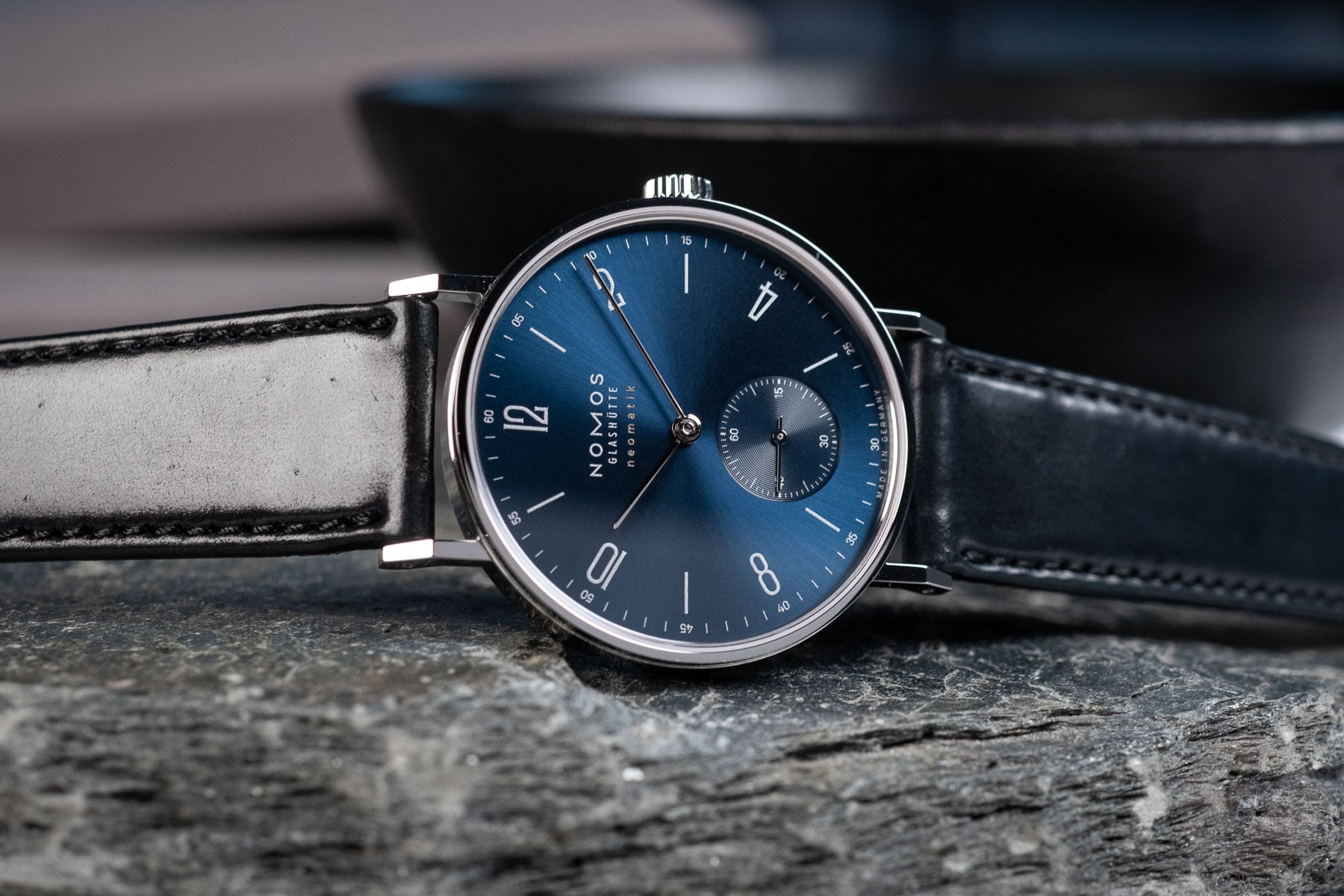 blue-dial Nomos Tangente Neomatik 39 on its side, crown up