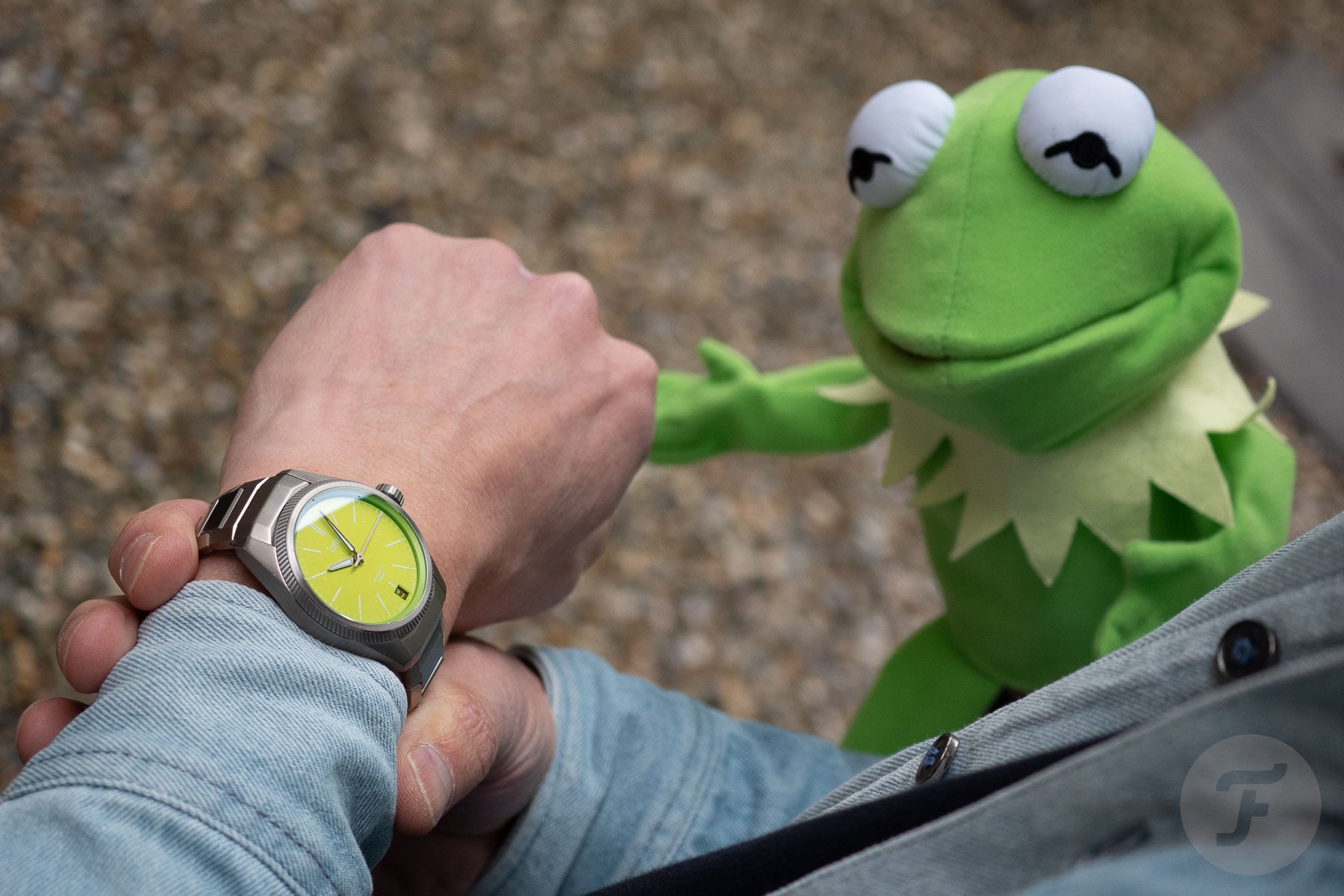 Oris ProPilor X Kermit edition on wrist with Kermit puppet