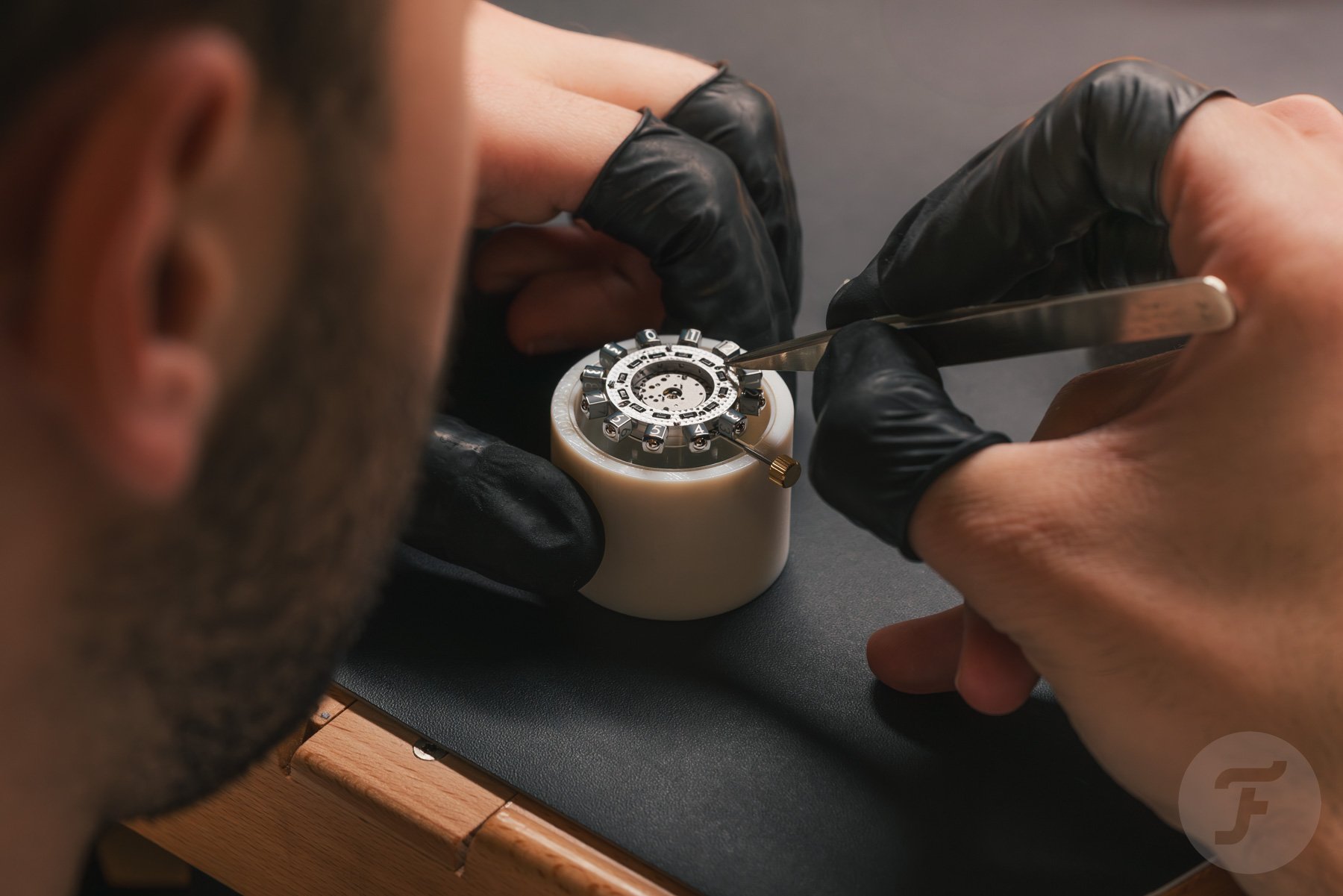 man working on Louis Vuitton Spin Time movement with tweezers