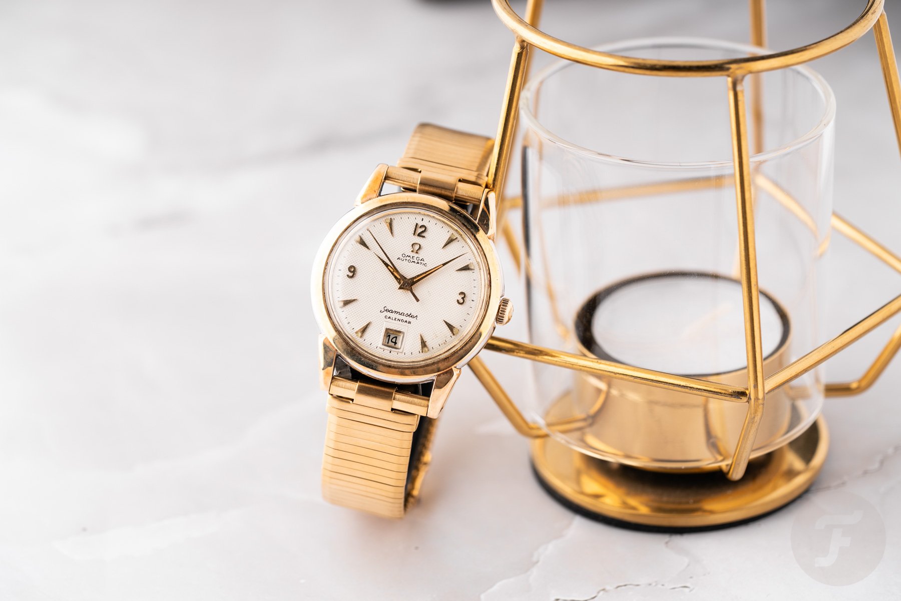 Gold-plated Fourstoner Comfit military bracelet of 1950s Omega sailors, supported by candles