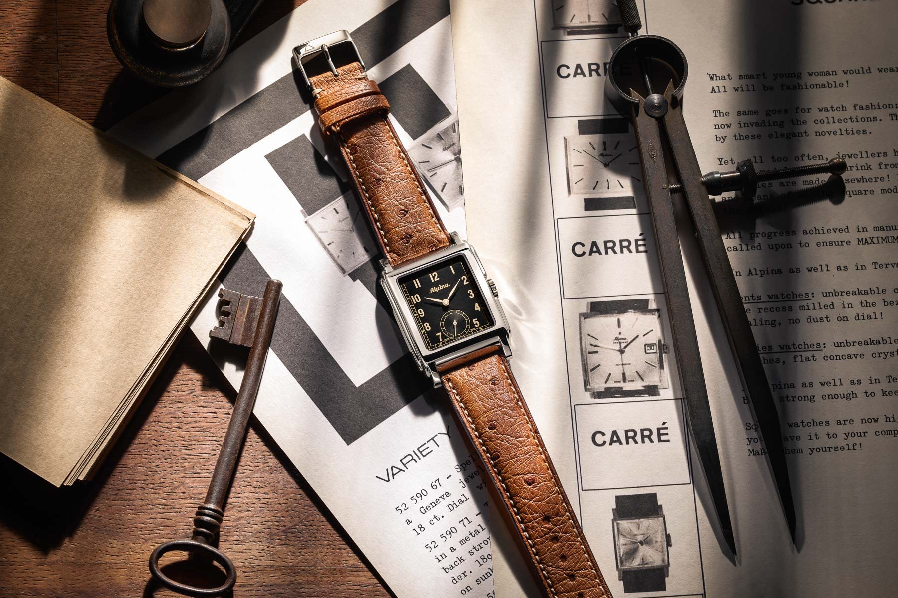 Flat lay of the Alpina Alpiner Heritage Carrée Automatic 140 Years