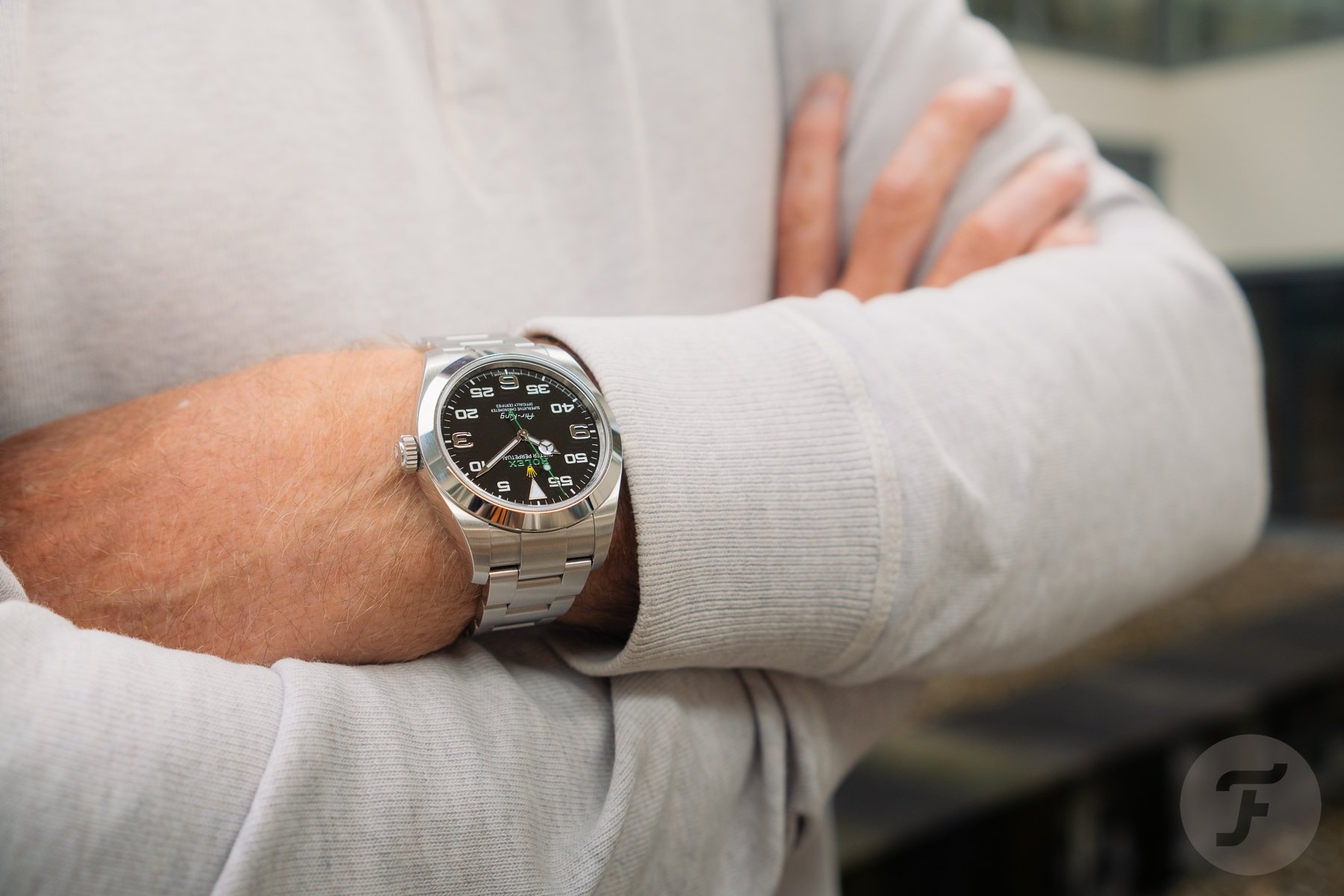 Rolex Air-King on wrist, arms crossed