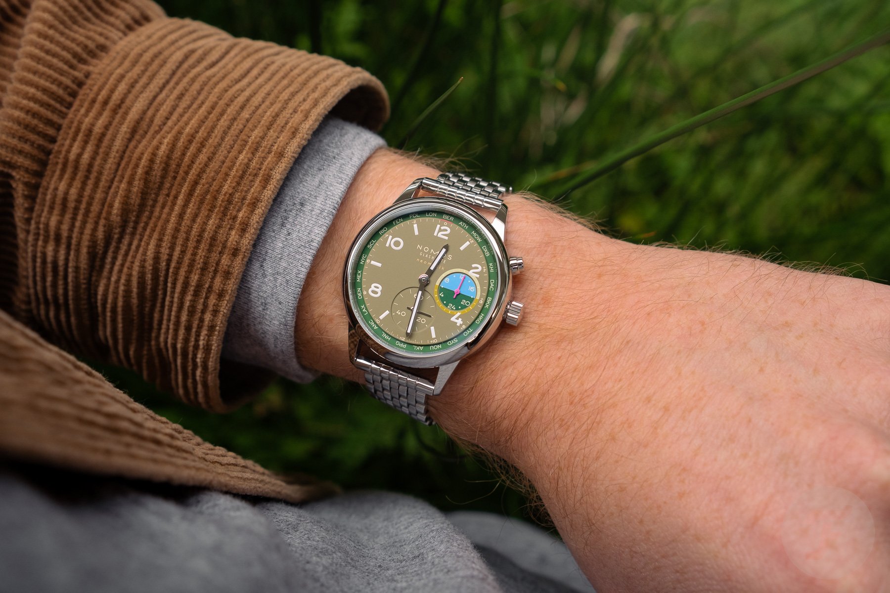Nomos Club Sport Neomatik Worldtimer Jungle on beads-of-rice bracelet, wrist shot
