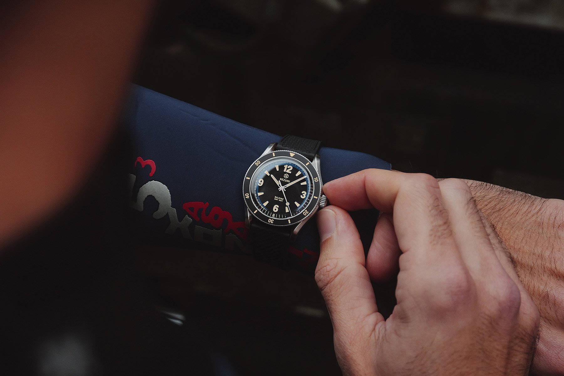 Nezumi Baleine BA4.102 on wrist over wetsuit, hand on crown