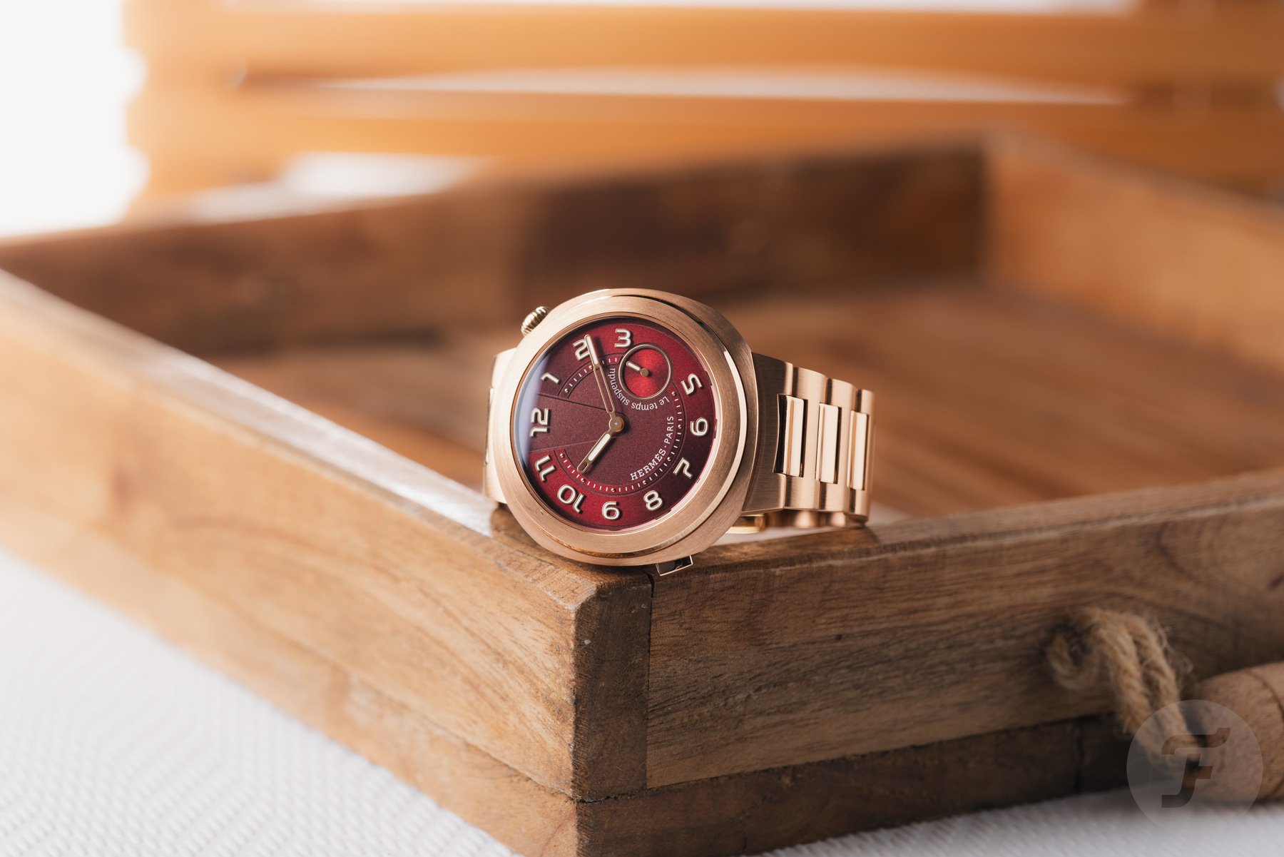 Hermès Cut Le Temps Suspendu on side on the corner of wooden tray