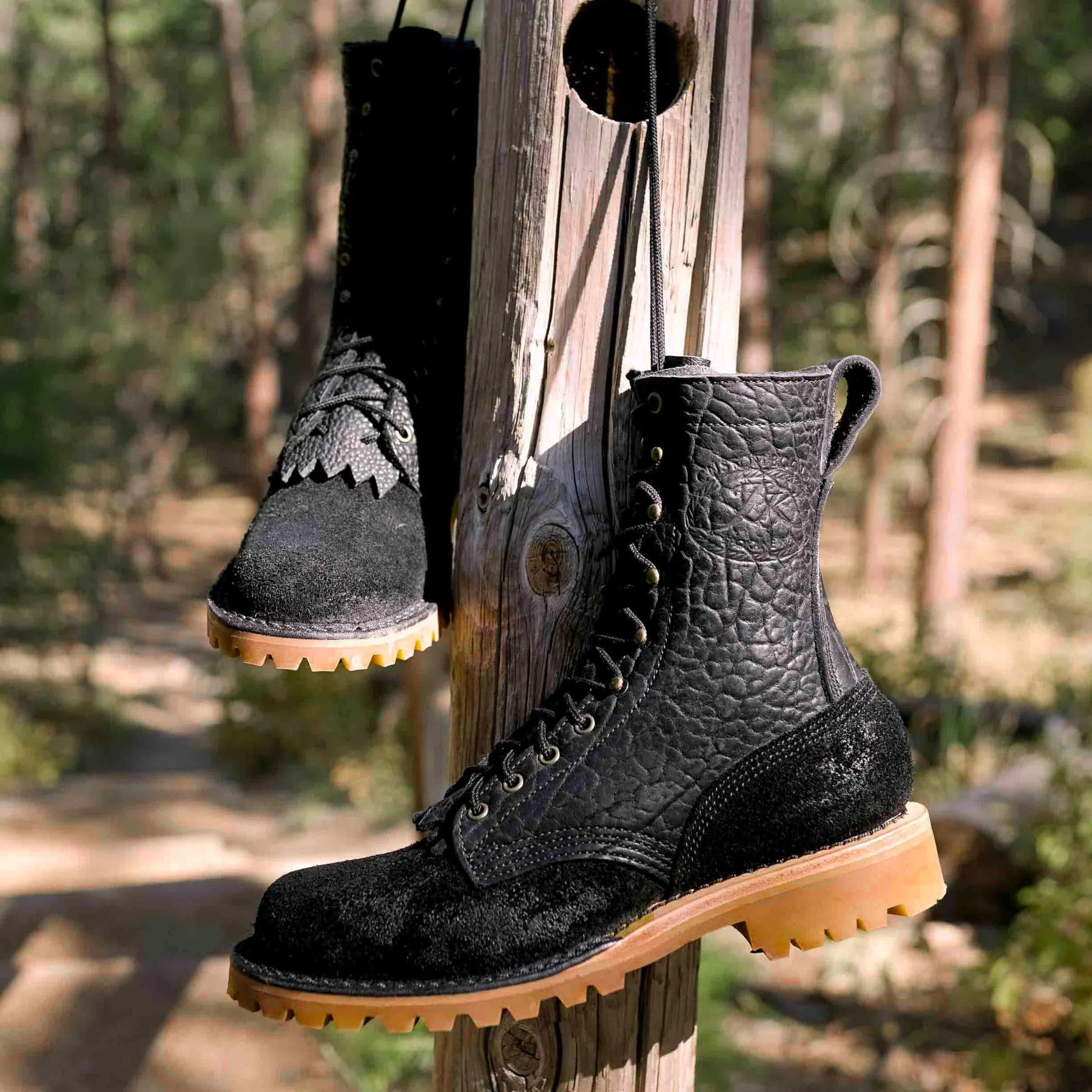 black JK Boots O.T. Bison boots hanging off a wooden pole