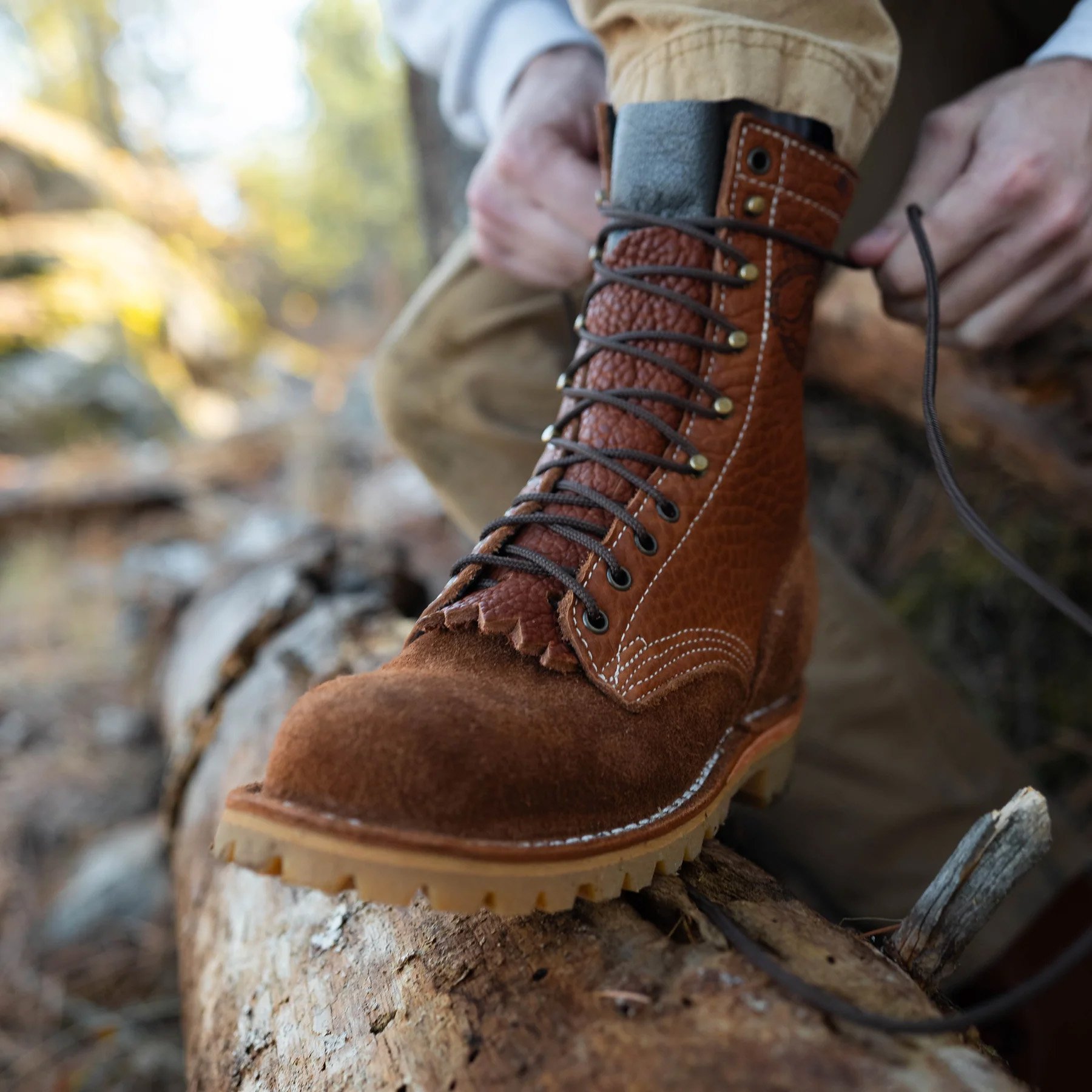 lacing up JK Boots O.T. Bison boots on log
