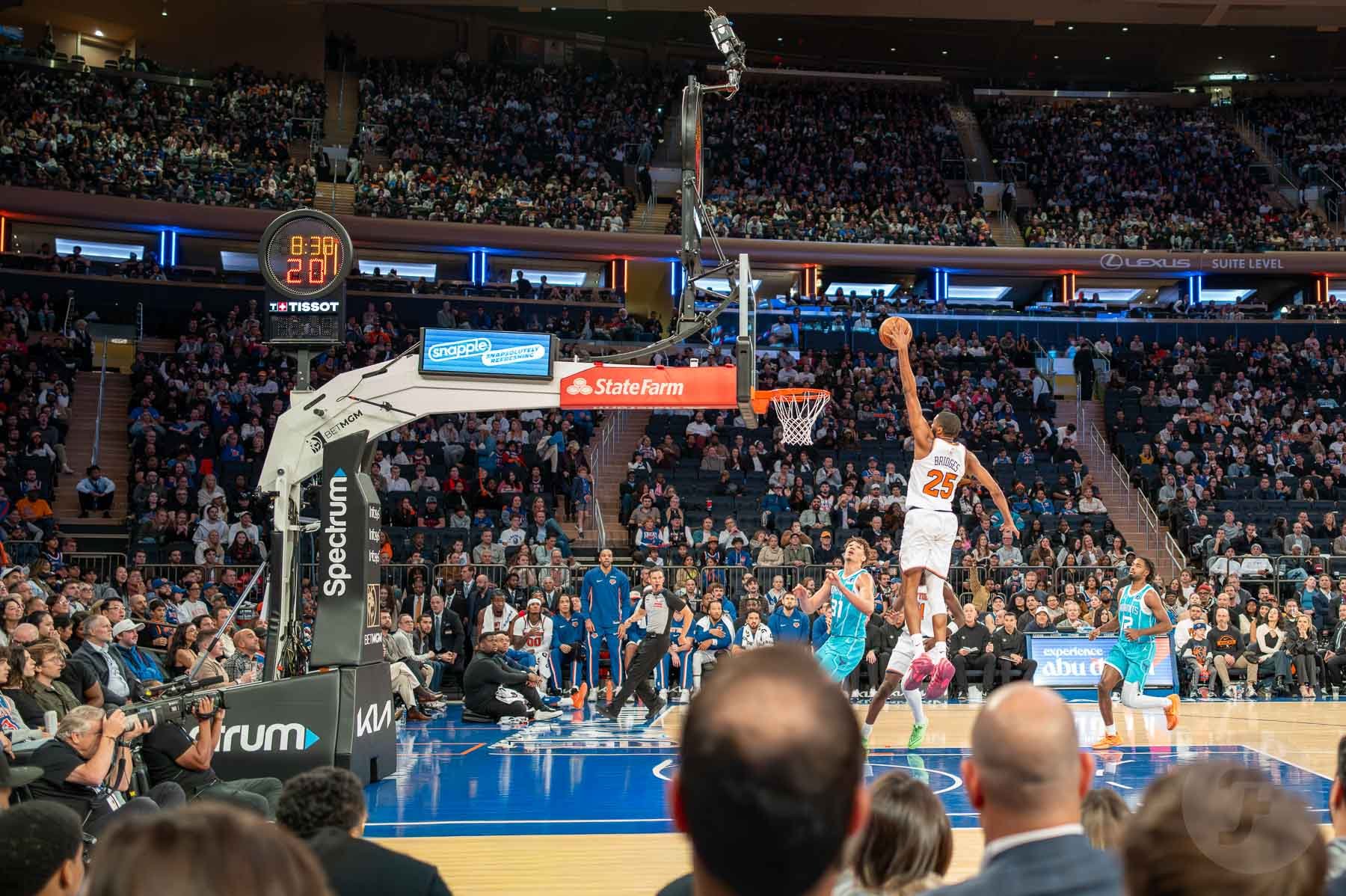 Mikal Bridges in mid-air, shooting a basketball, and a Tissot NBA shot clock