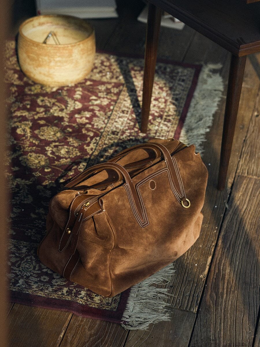 Songmont Medium Yore Duffle Bag in Sandal Suede on floor