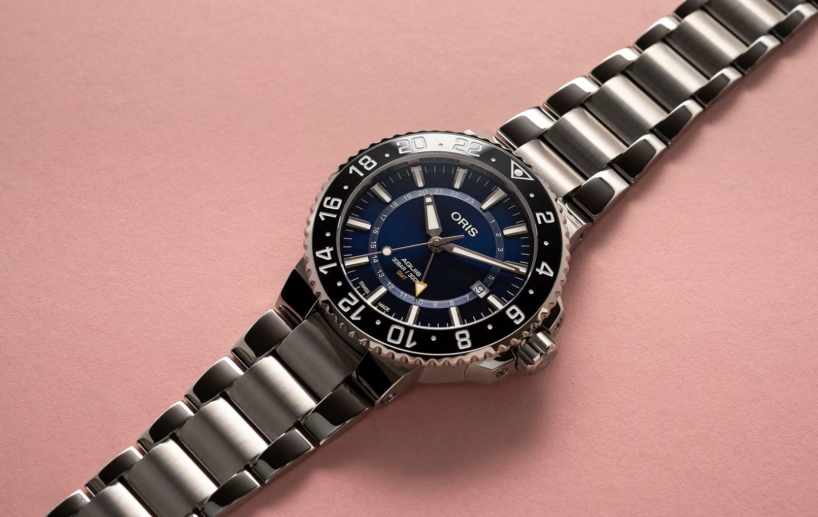 Oris Aquis GMT Date omn a pink background