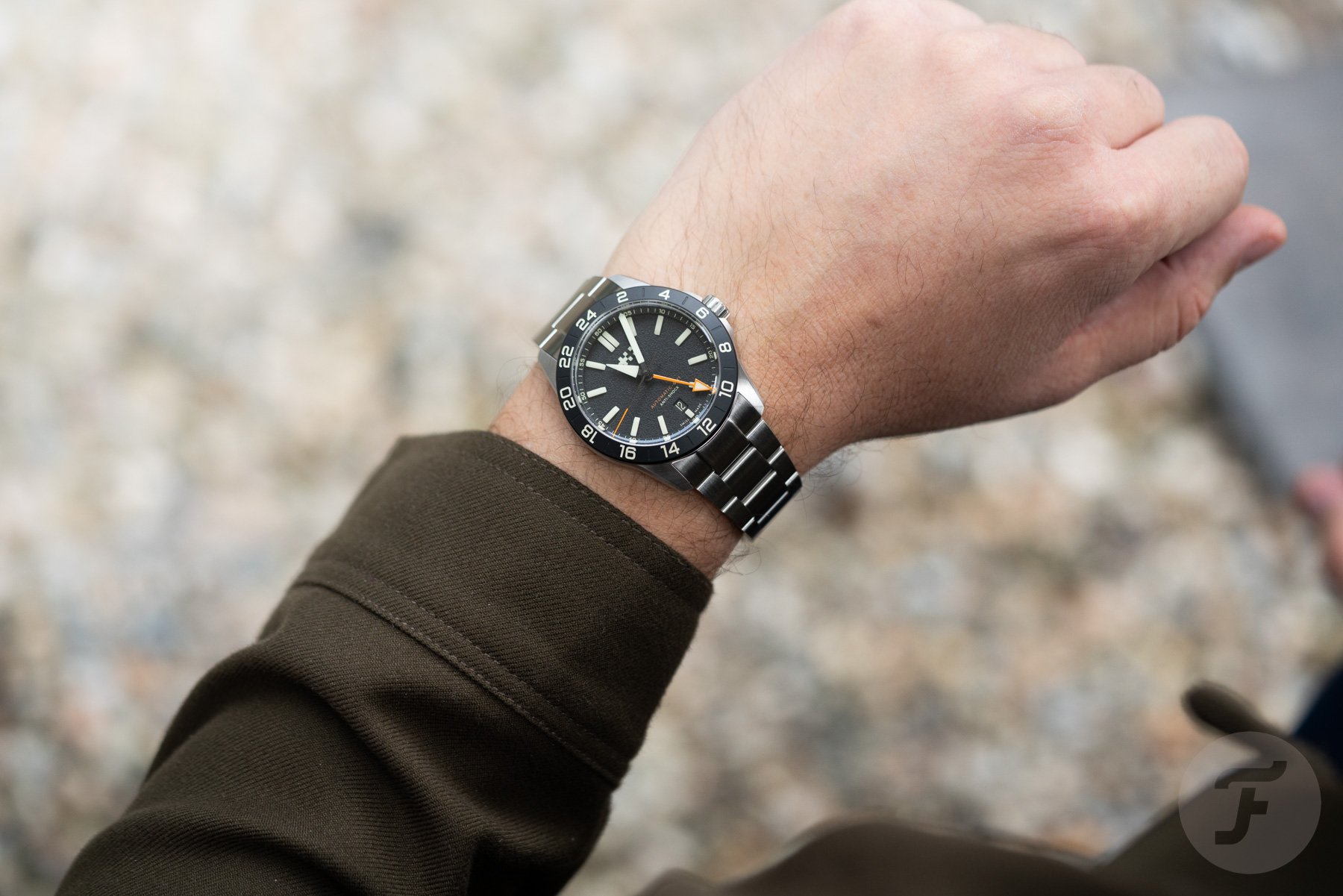black-dial Christopher Ward C63 Sealander Extreme GMT on wrist, over-shoulder shot