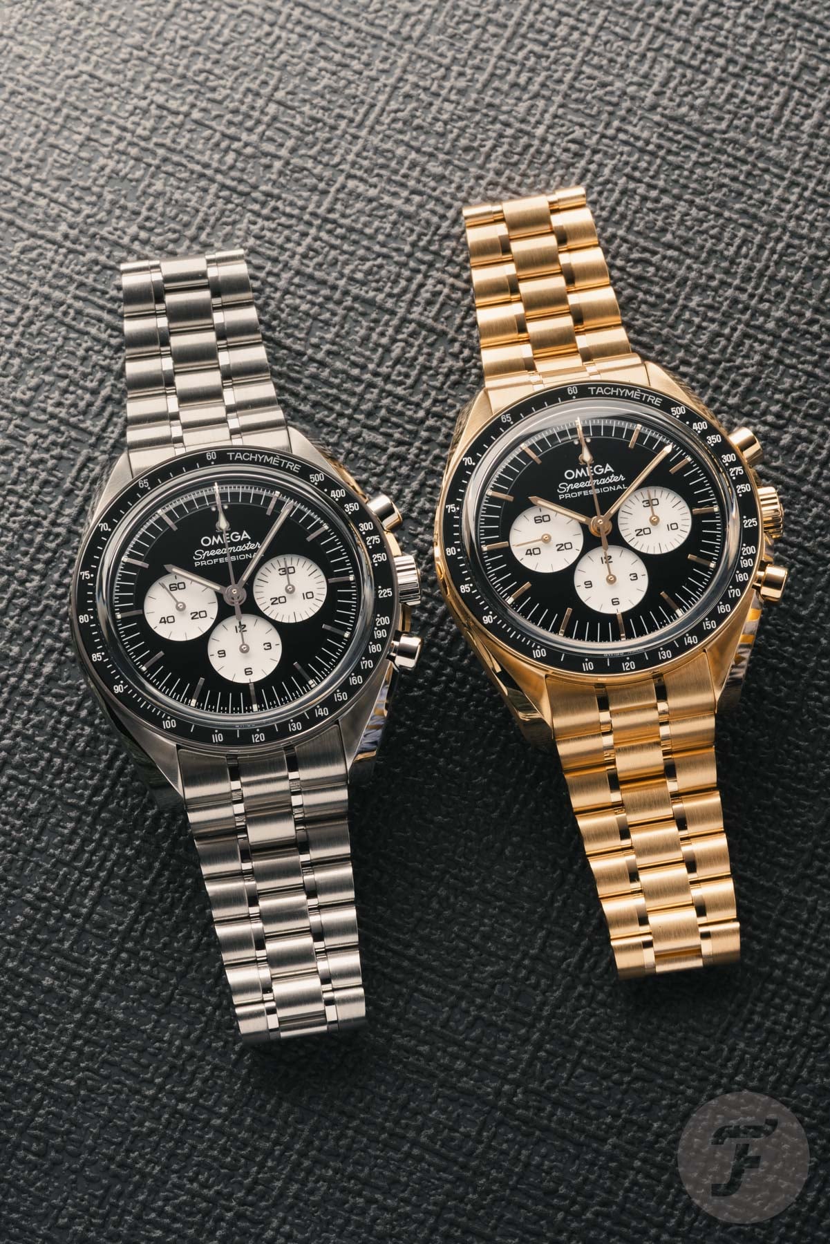 Omega Speedmaster Moonwatch Professional "Reverse Panda" refs. 310.30.42.50.01.004 and 310.60.42.50.01.002 side by side, flat-lay
