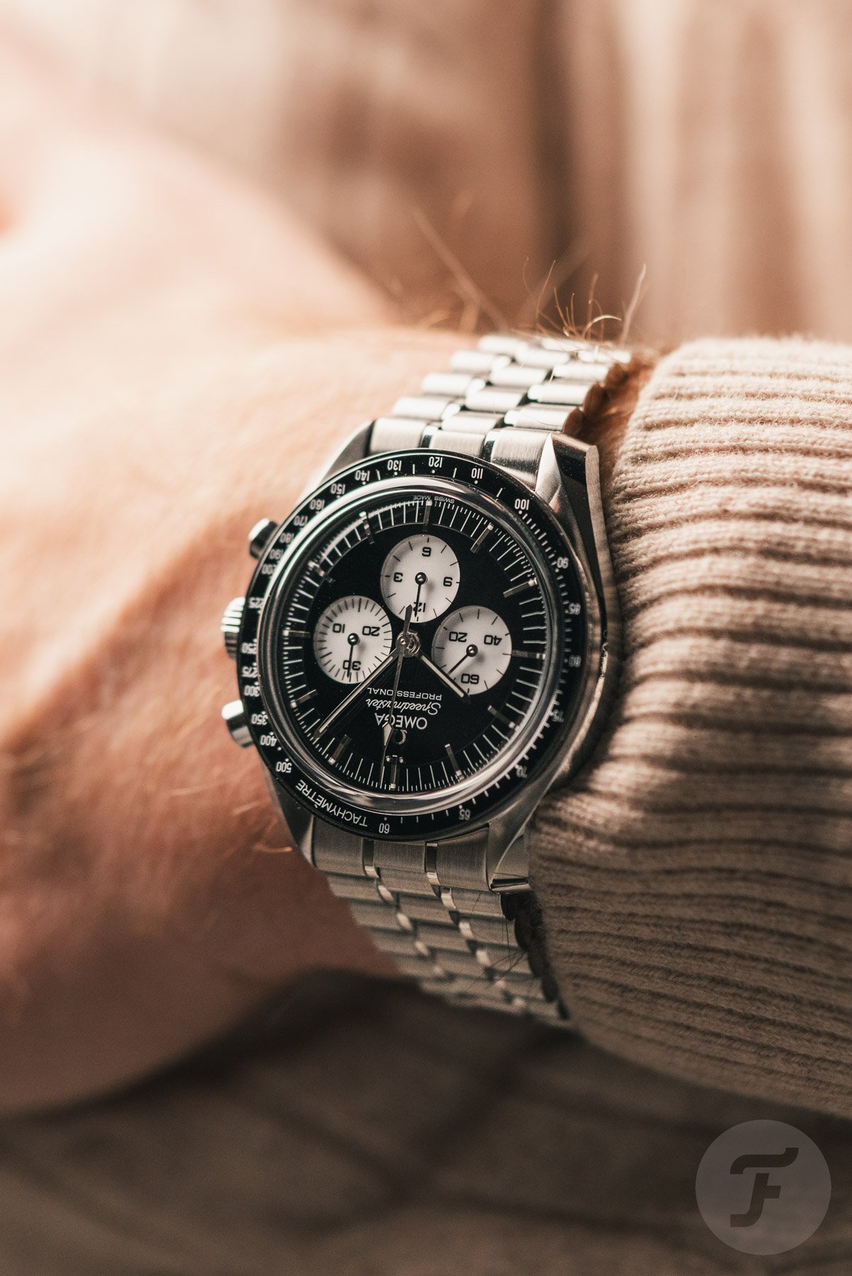 Omega Speedmaster Moonwatch Professional "Reverse Panda" ref. 310.30.42.50.01.004 on wrist, arms crossed