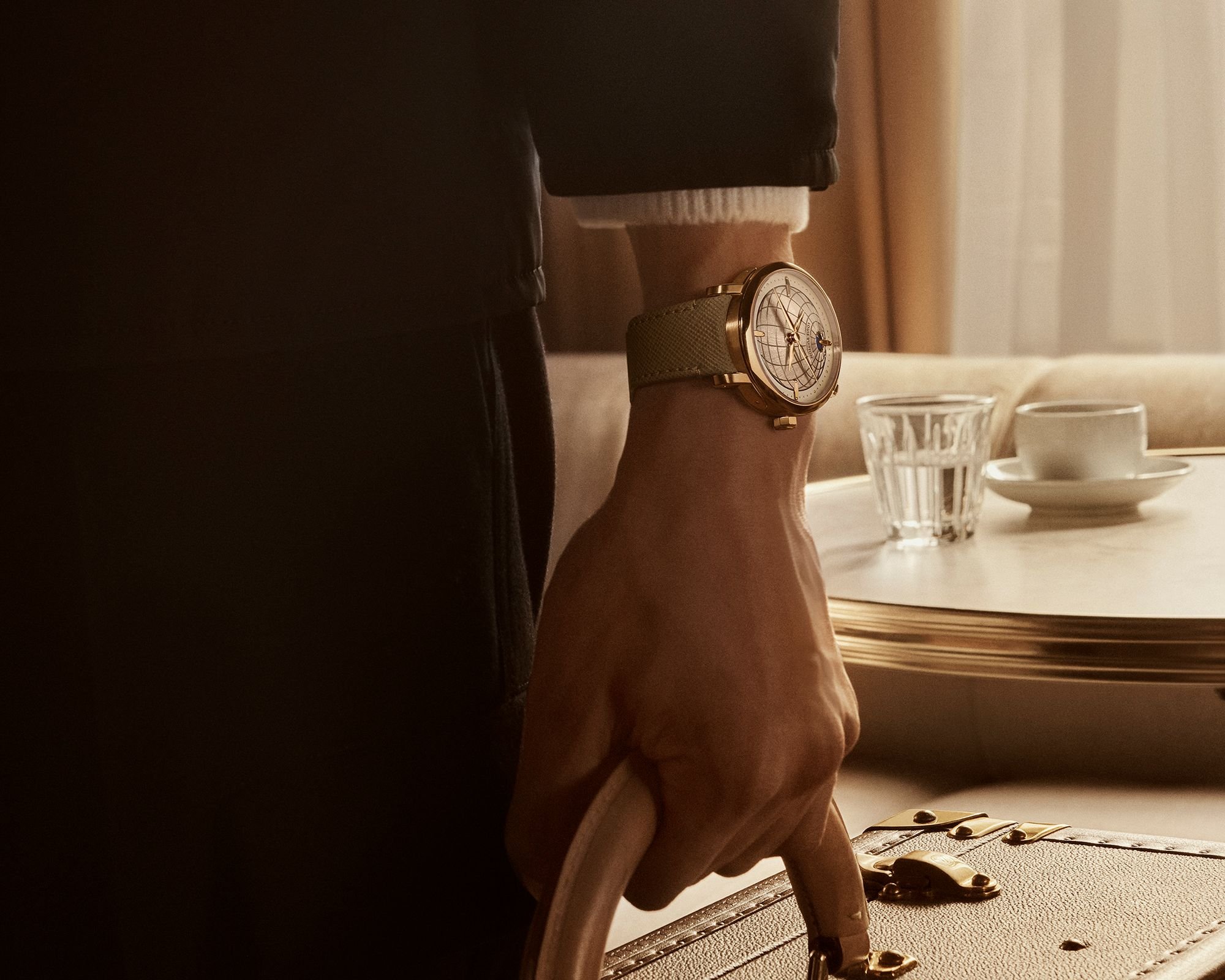 Louis Vuitton Escale Twin Zone on wrist of man holding suitcase