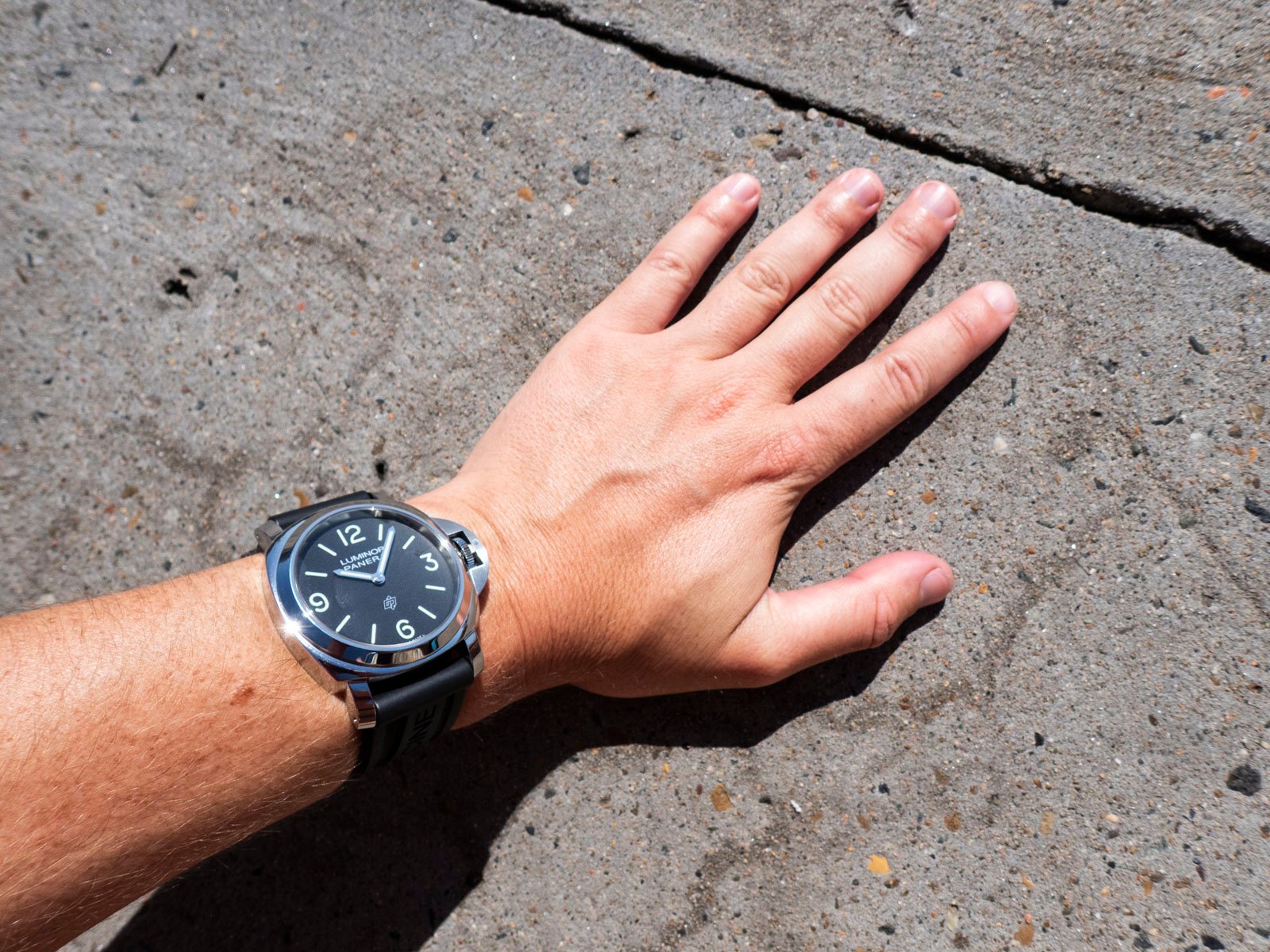 Panerai Luminor Base Logo PAM01086 wrist shot, hand on flat rock