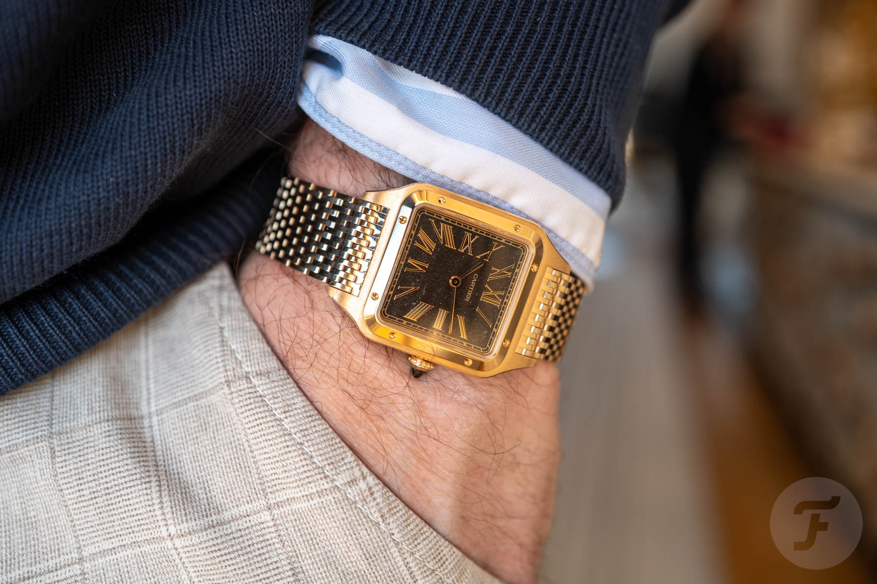 pocket shot of gold Cartier Santos-Dumont with bracelet and obsidian dial