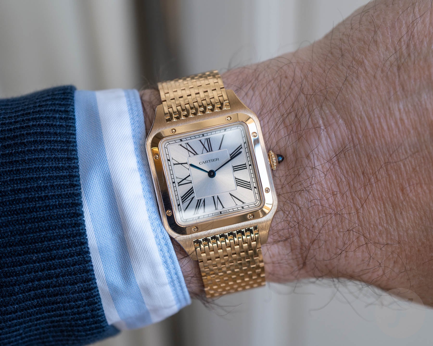 wrist shot of gold Cartier Santos-Dumont with bracelet