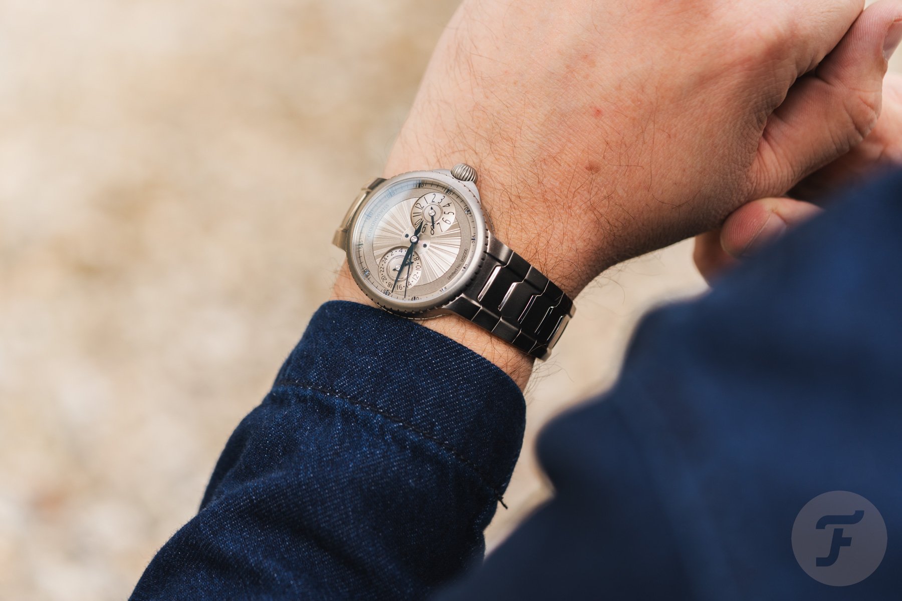 titanium Chronoswiss Pulse GMT on wrist, over-shoulder shot