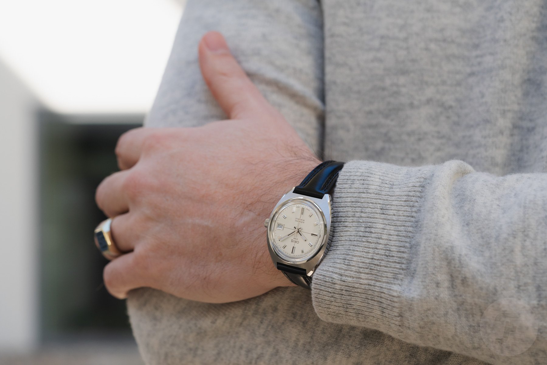 Oris Star re-edition on wrist, arms crossed