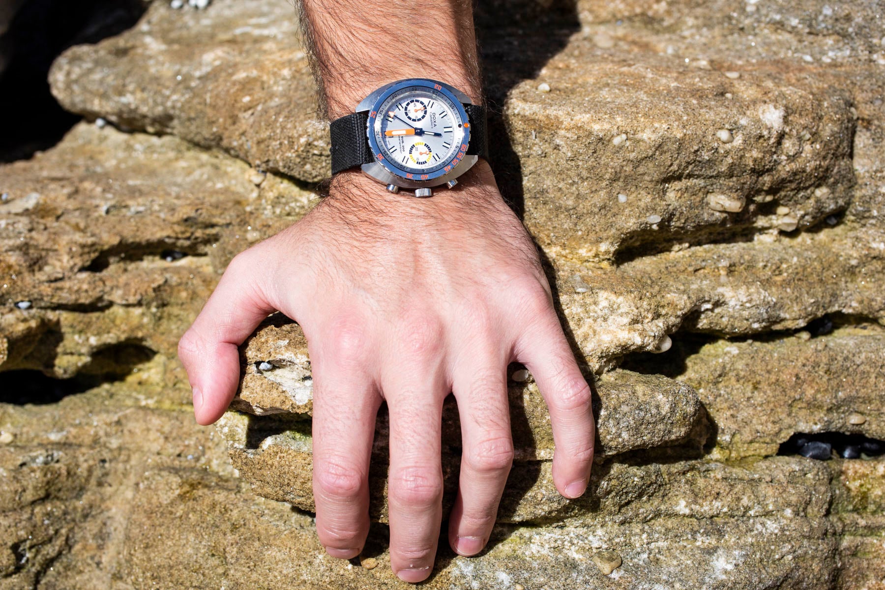Doxa Sub 200 T.Graph II Searambler on wrist, hand on rock