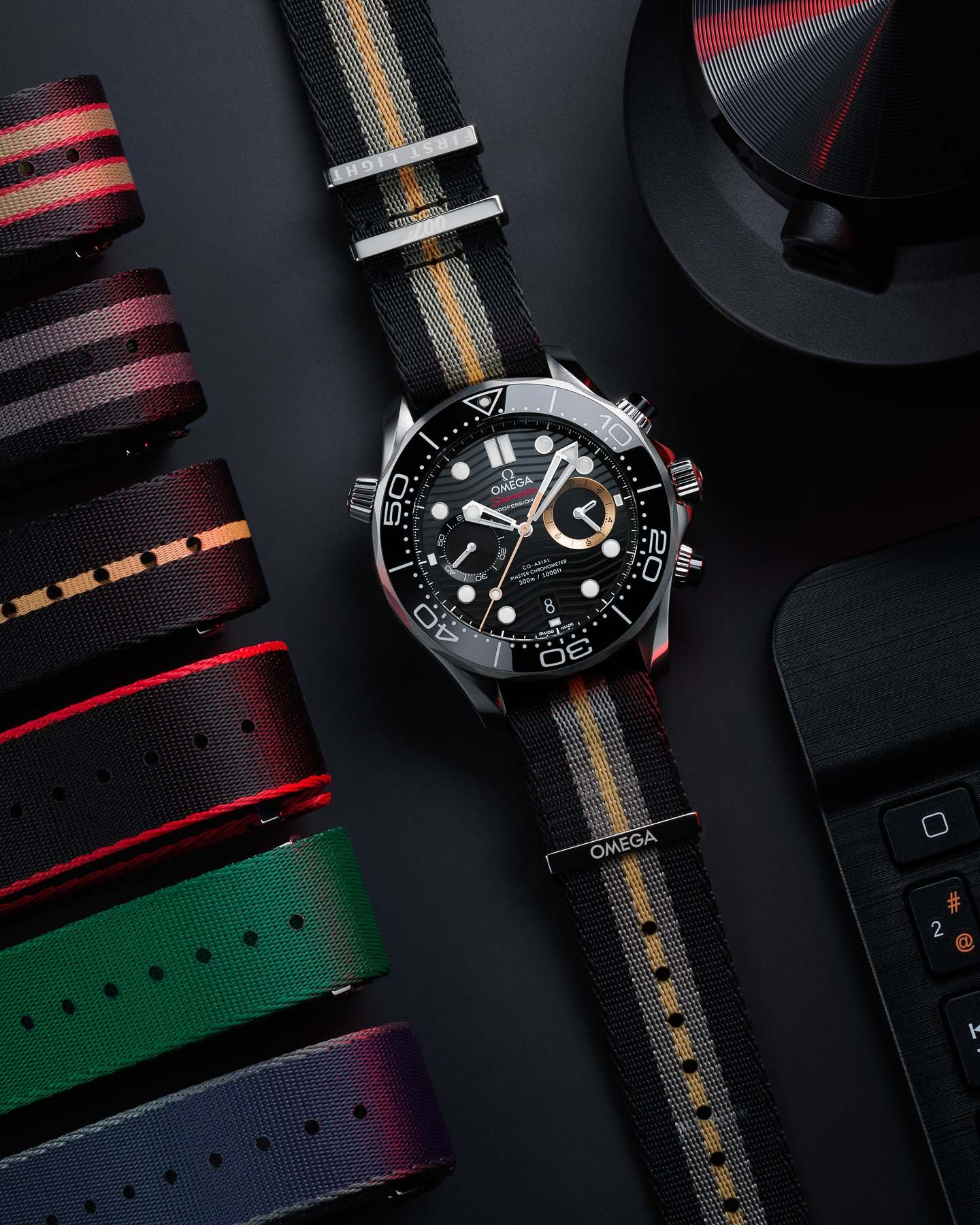 Omega Seamaster Diver 300M Chronograph 007 First Light flat-lay with other NATO straps