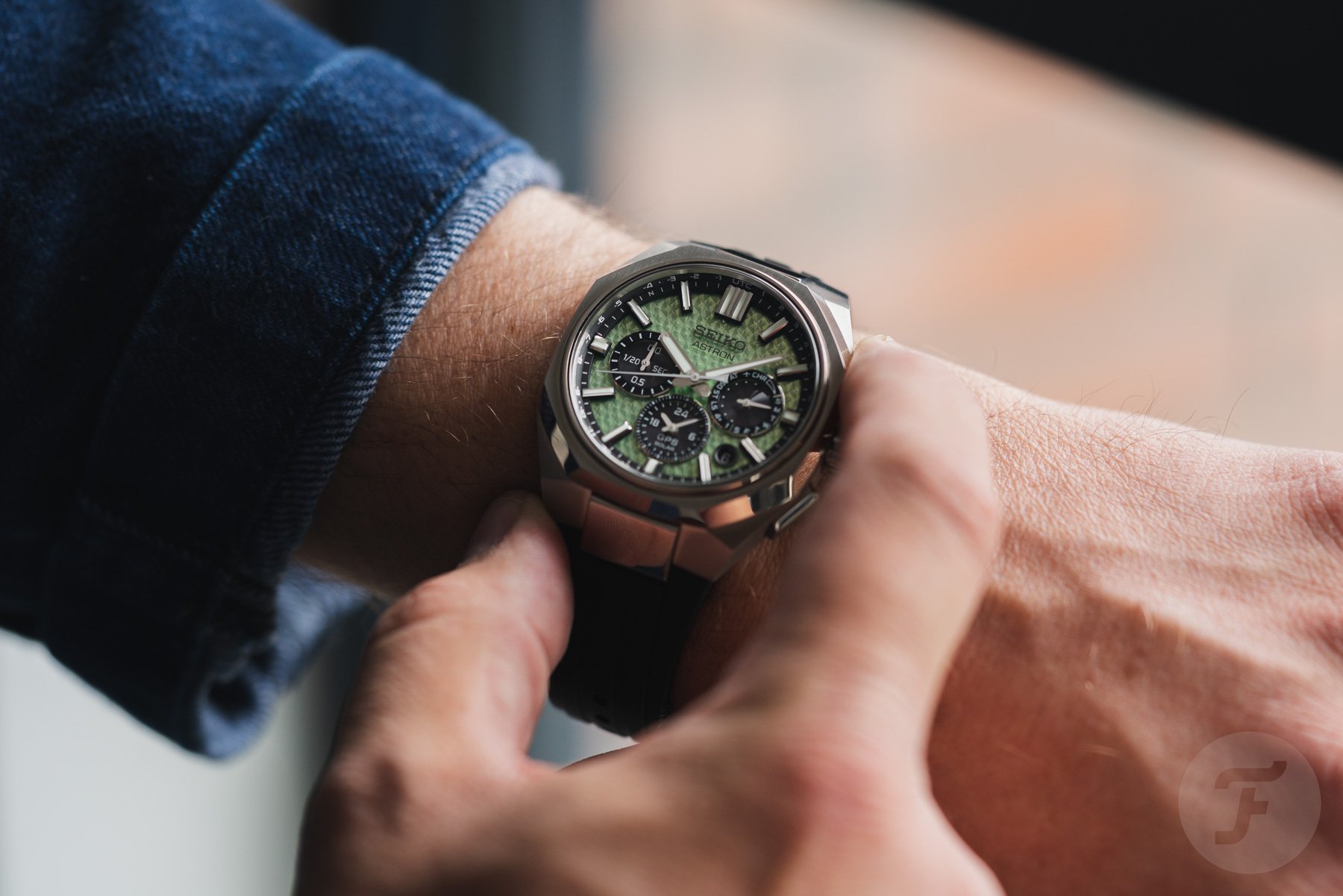 Seiko Astron GPS Solar Dual-Time Chronograph Crystal Green (HAB005) on wrist, finger on pusher