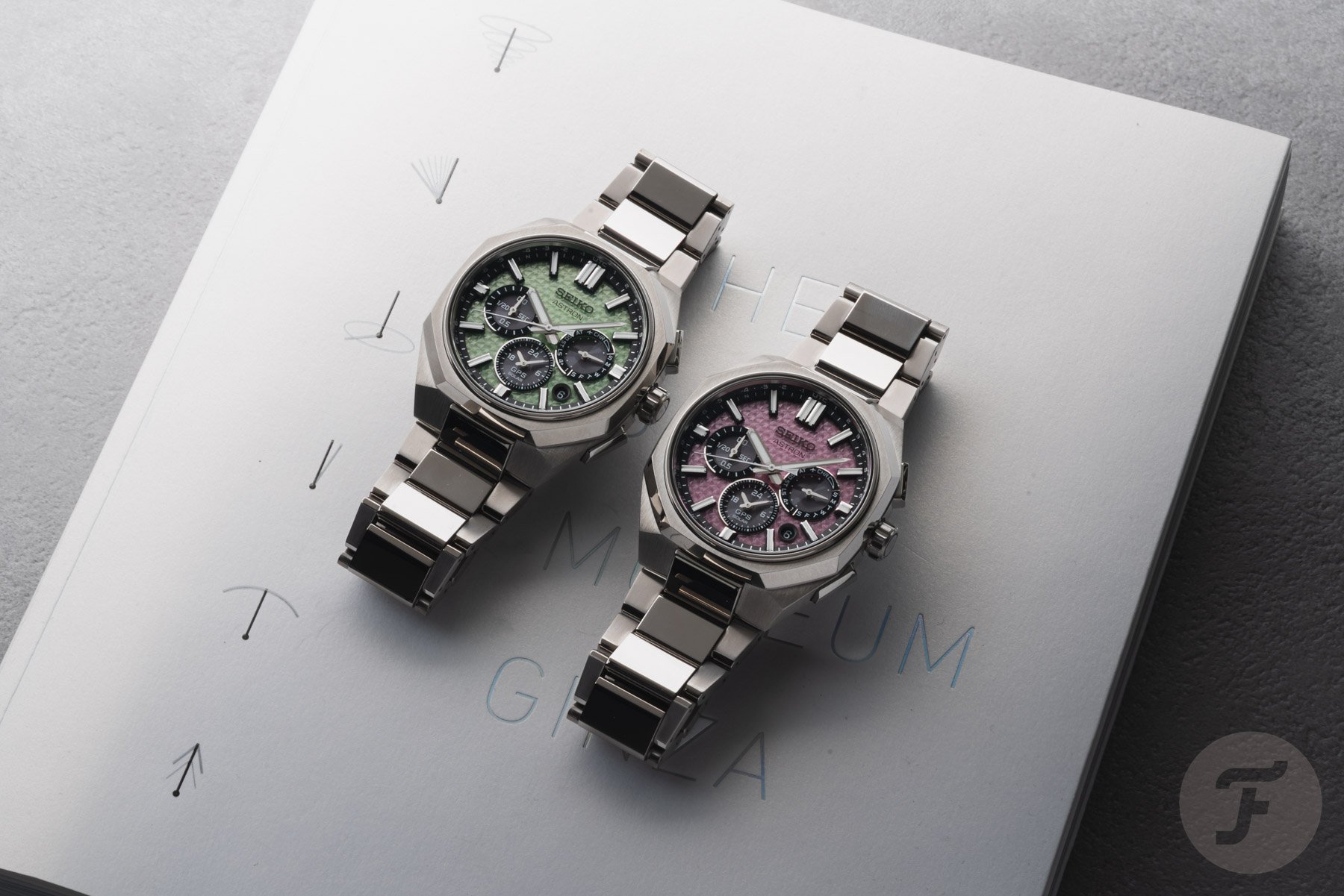 Seiko Astron GPS Solar Dual-Time Chronograph In Crystal Green (HAB005) and Crystal Pink (HAB006) side by side flat-lay