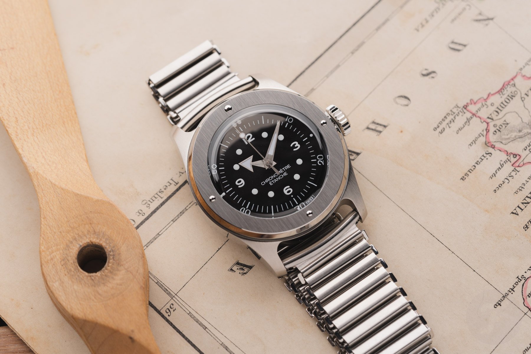 black-dial Serica 7505 on map, flat-lay