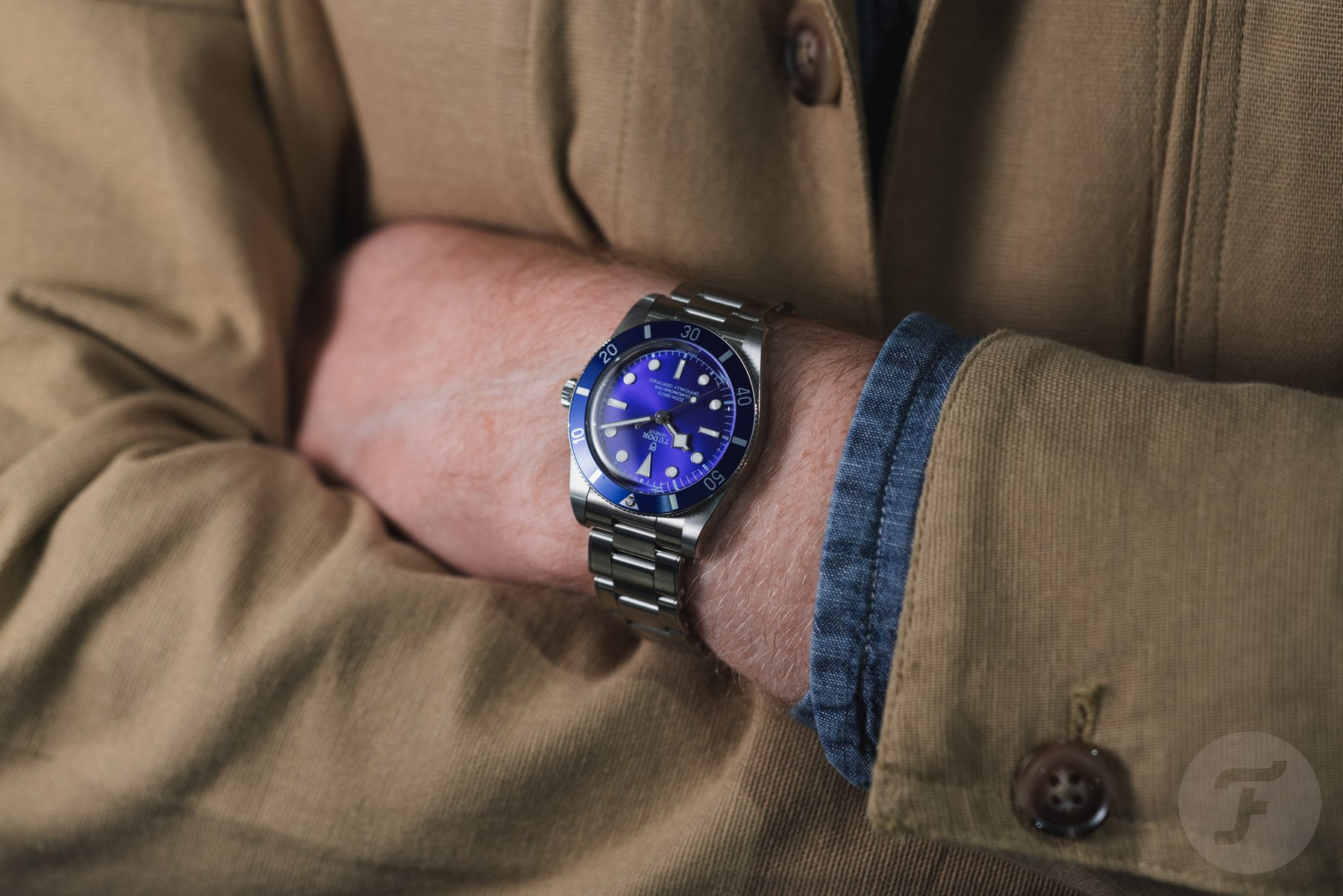 blue Tudor Black Bay 54 on wrist, arms folded