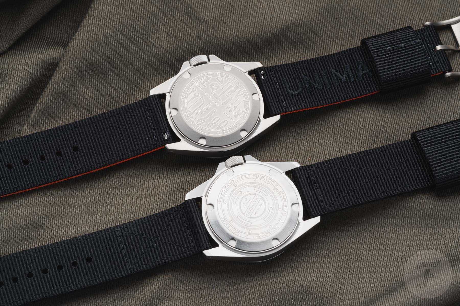 Unimatic Modello Quattro UT4-U-TI-GMT and UT4-GMT face down, side by side, showing case backs