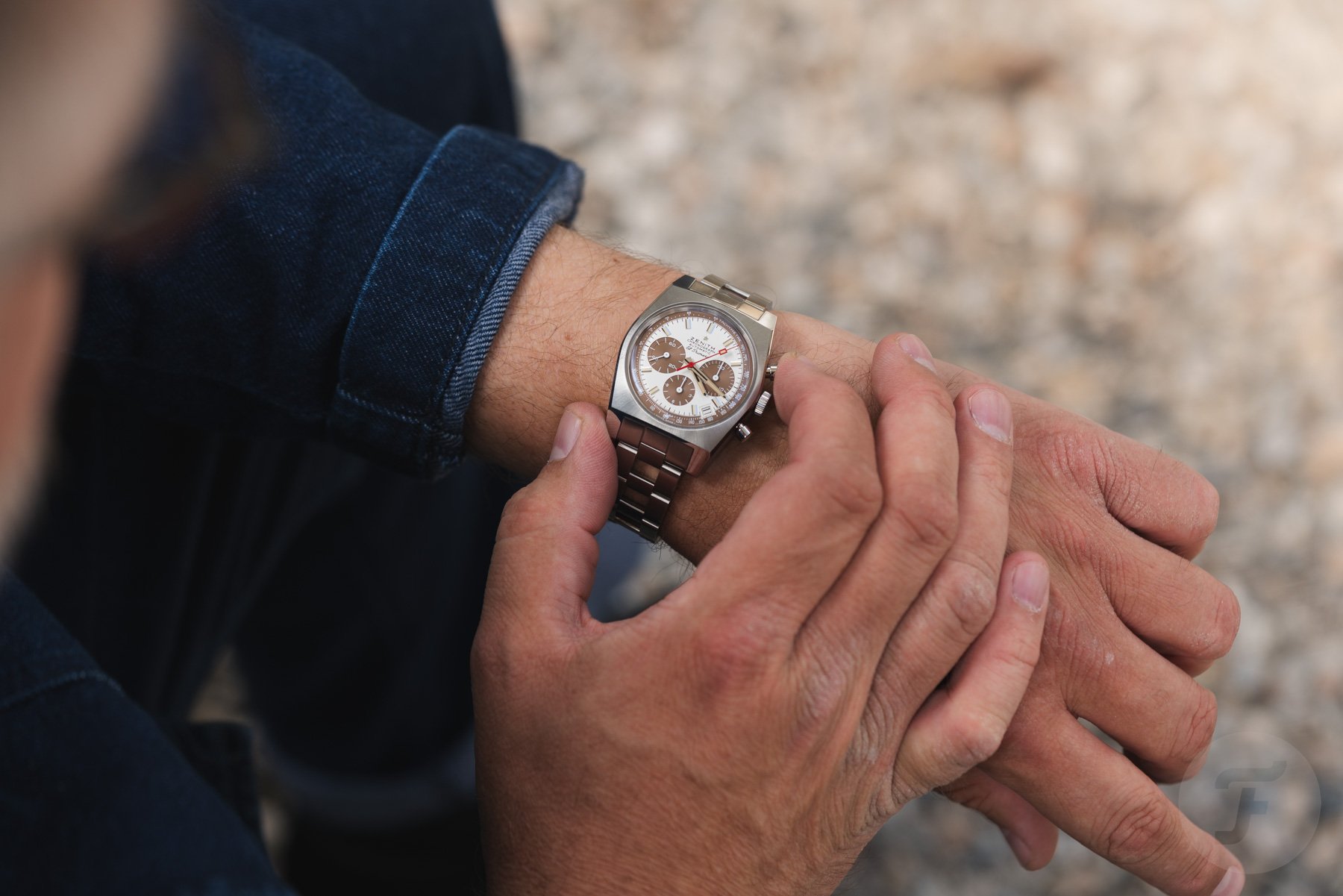 Zenith Chronomaster Revival A384 Tropical on wrist, finger on pusher, over-shoulder shot