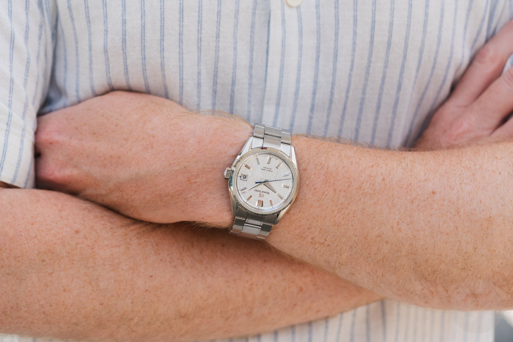 Grand Seiko Evolution 9 Hi-Beat SLGH031 on wrist, arms crossed