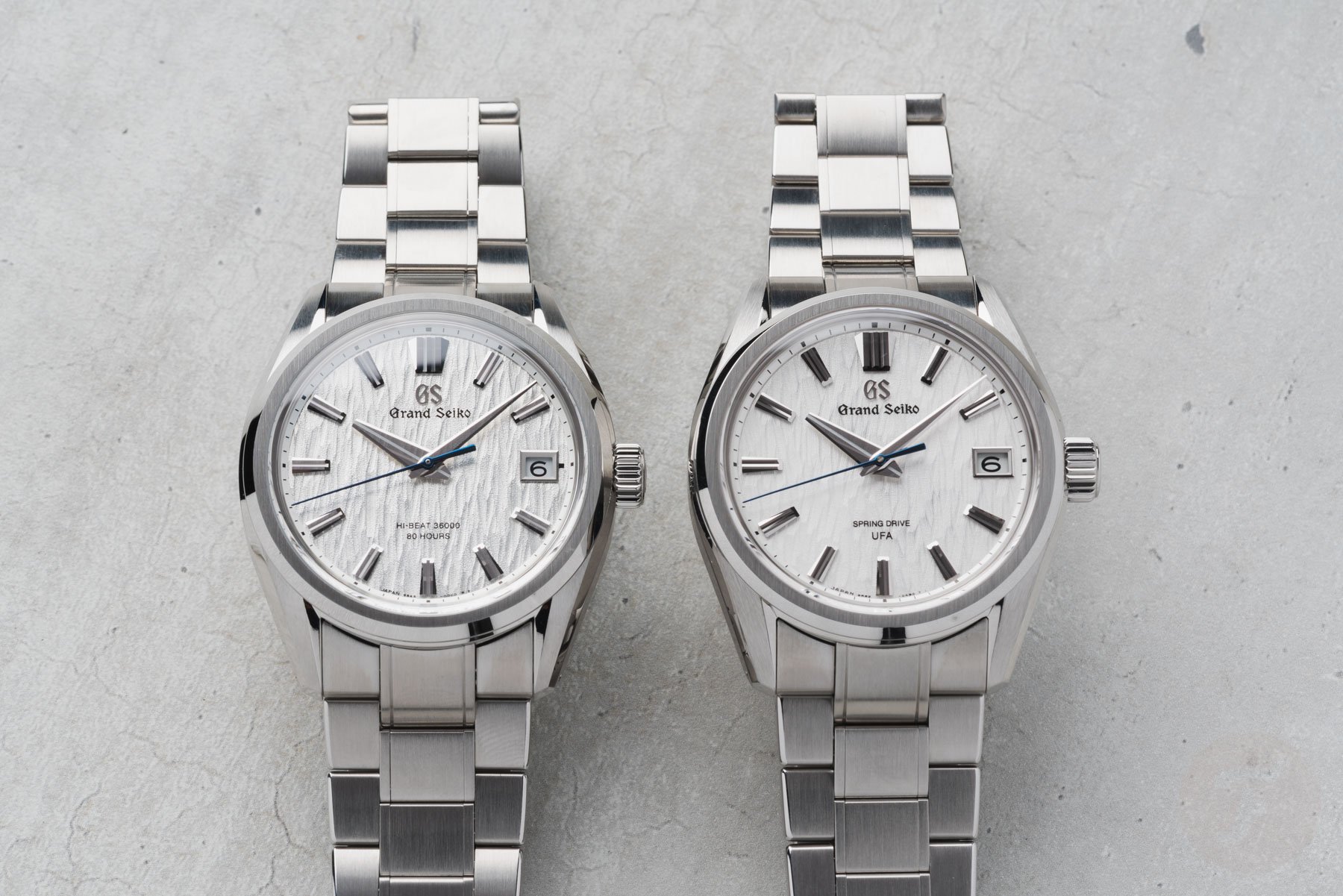 Grand Seiko Evolution 9 Collection Hi-Beat 36000 SLGH031 next to Spring Drive U.F.A. SLGB009, flat-lay
