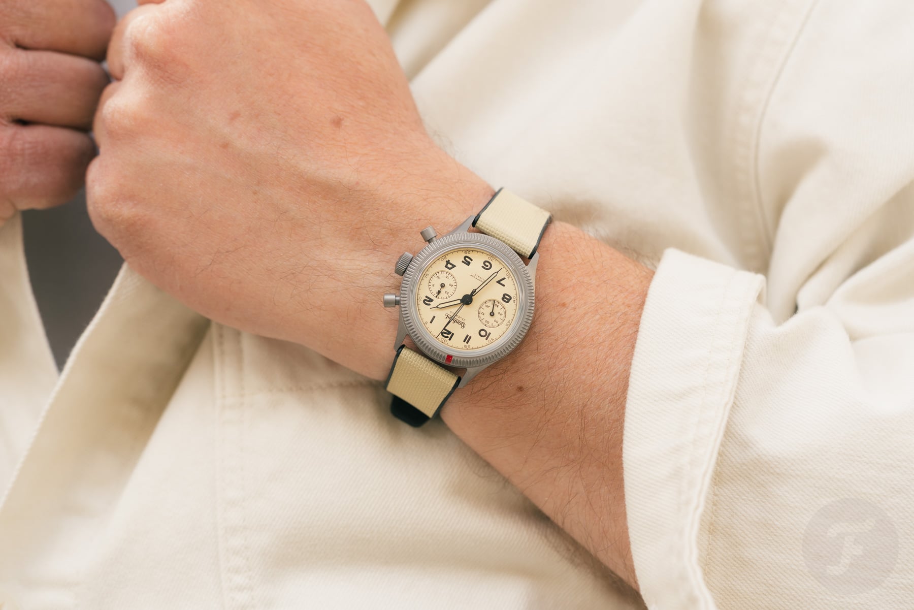 Hanhart 417 TI Desert Pilot on wrist, hands on lapel