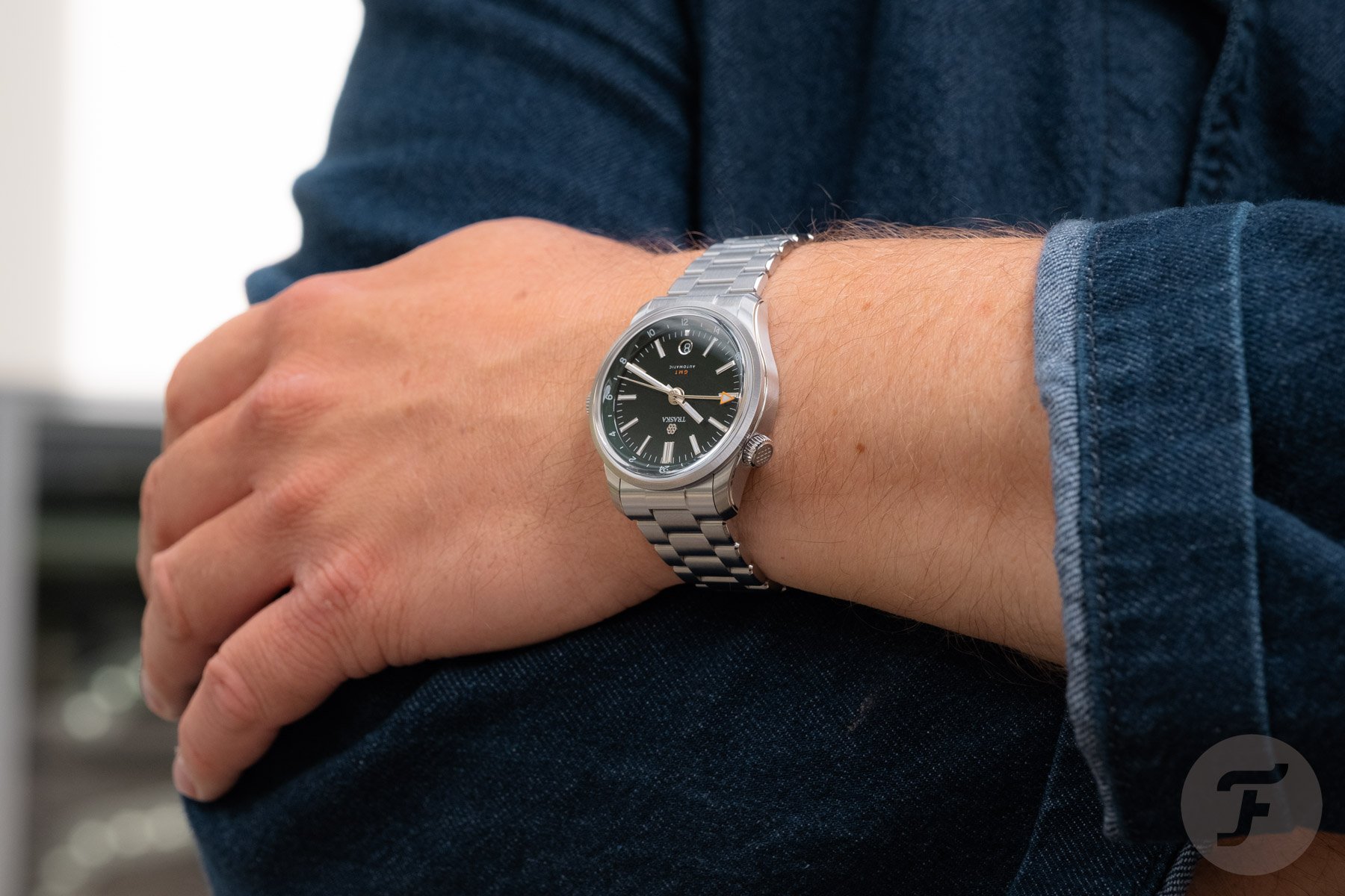 Traska Venturer GMT Bottle Green on wrist, arms folded