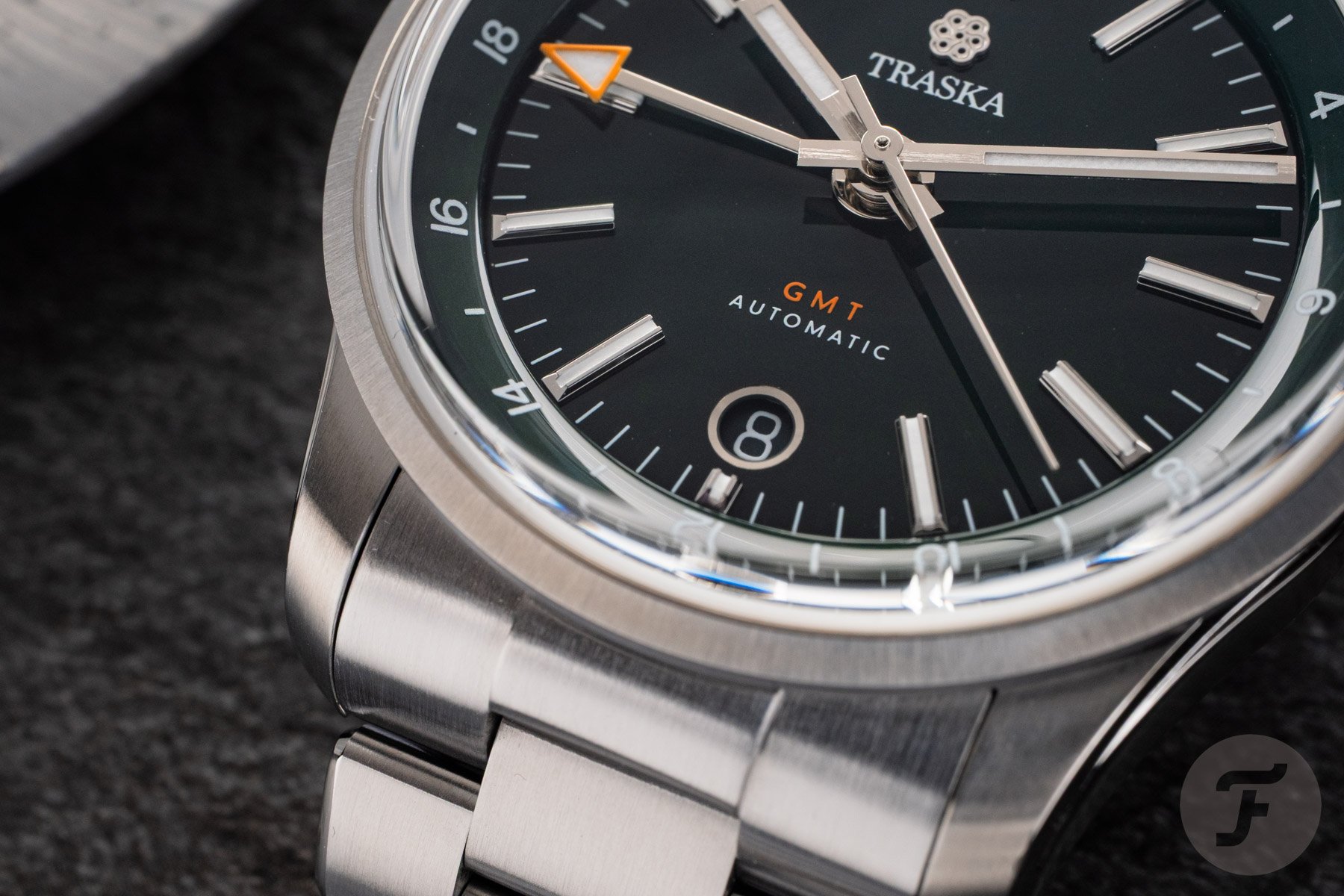 Traska Venturer GMT Bottle Green dial, bezel, and end link up close