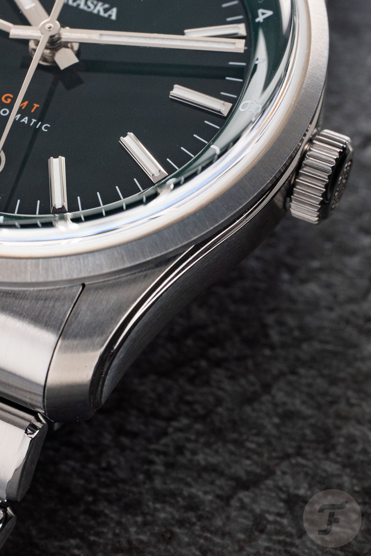 Traska Venturer GMT Bottle Green bezel, lug, and crown detail