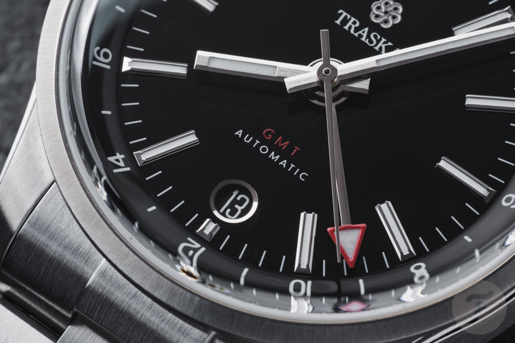Traska Venturer GMT Carbon Black indexes, date window, and GMT hand up close