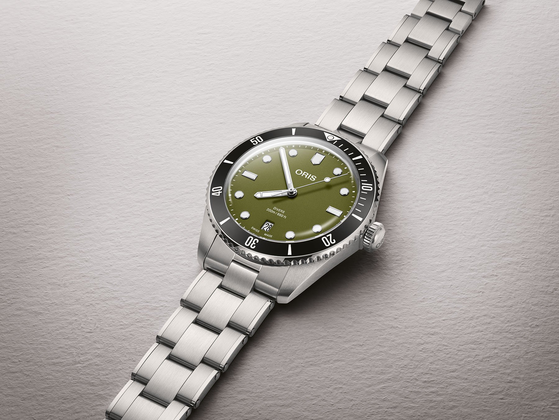 green-dial Oris Divers Date flat-lay