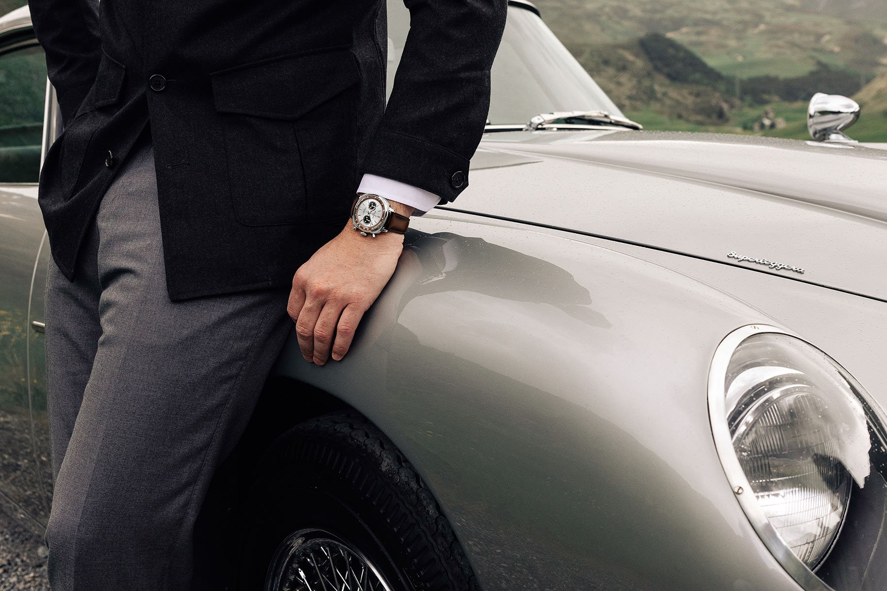 Breitling Top Time B01 Chronograph 41 Tribute to Aston Martin DB5 ref. AB0178121G1X1 on wrist of man leaning against car