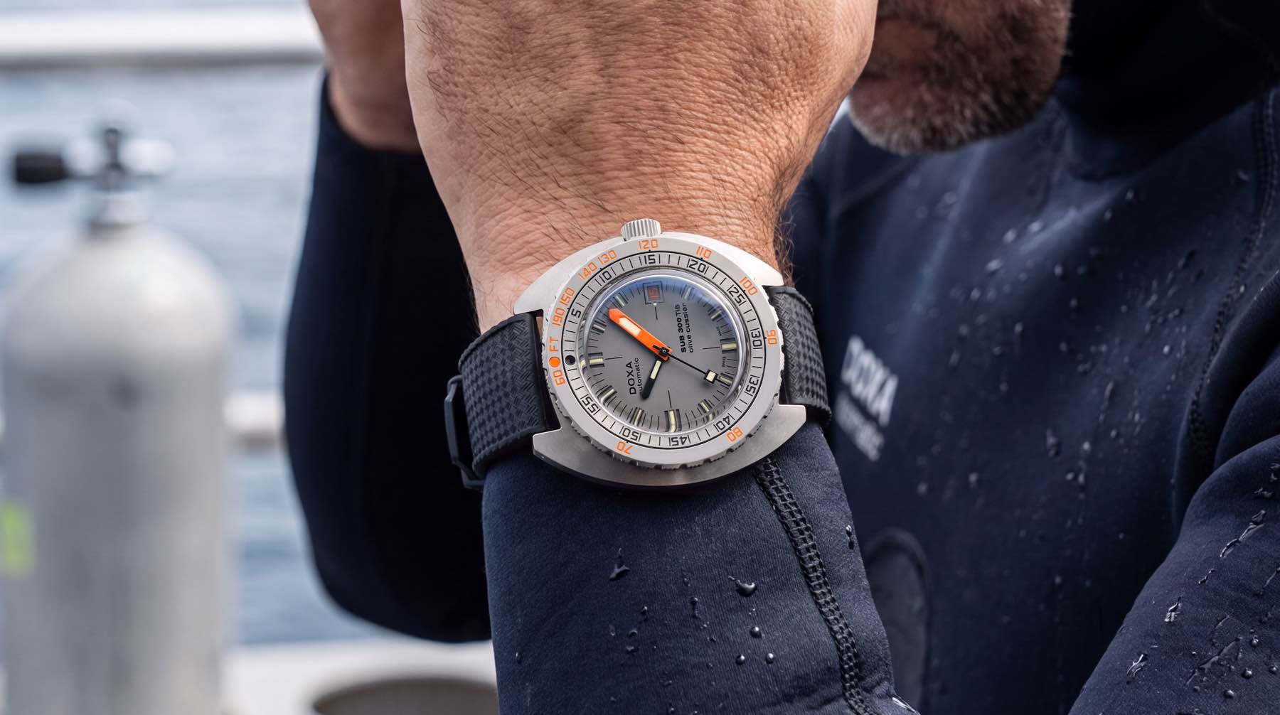 Doxa Sub 300 Ti5 Clive Cussler on wrist of man in wetsuit