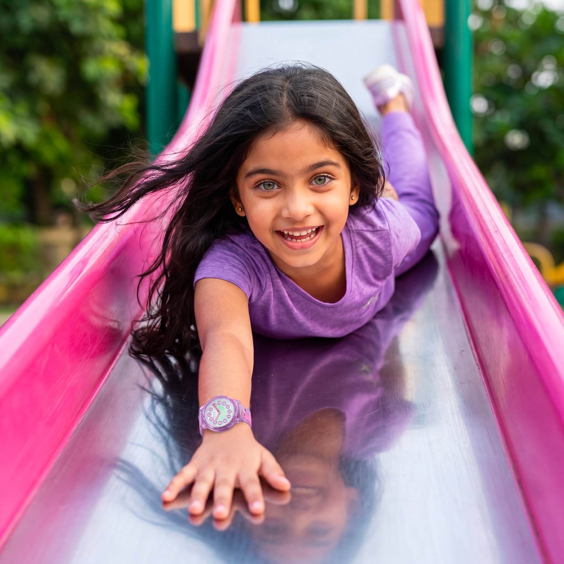 Girl wearing the Mc Onsen Cybex Flamingo watch while on a slide